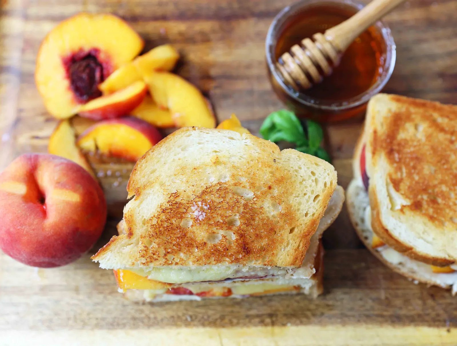 Honey Peach White Cheddar Grilled Cheese Sandwich. A summer grilled cheese sandwich with sweet juicy peaches, white cheddar cheese, a drizzle of honey on buttery toasted bread. www.modernhoney.com #peaches #grilledcheese #peachgrilledcheese