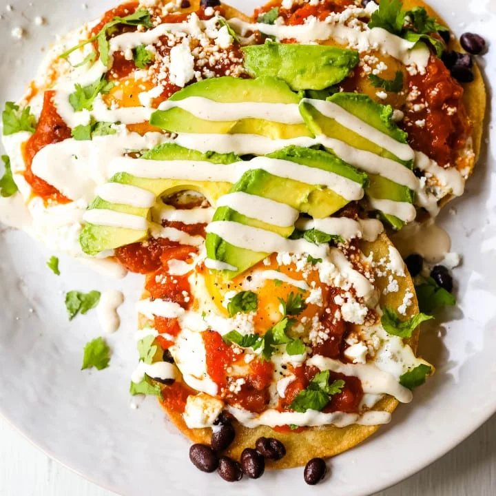 Huevos Rancheros. A traditional Mexican breakfast dish made with fried corn tortillas, fried egg, ranchera salsa, beans, avocado, cheese, and salsa. #huevosrancheros #mexican #mexicanfood #breakfast