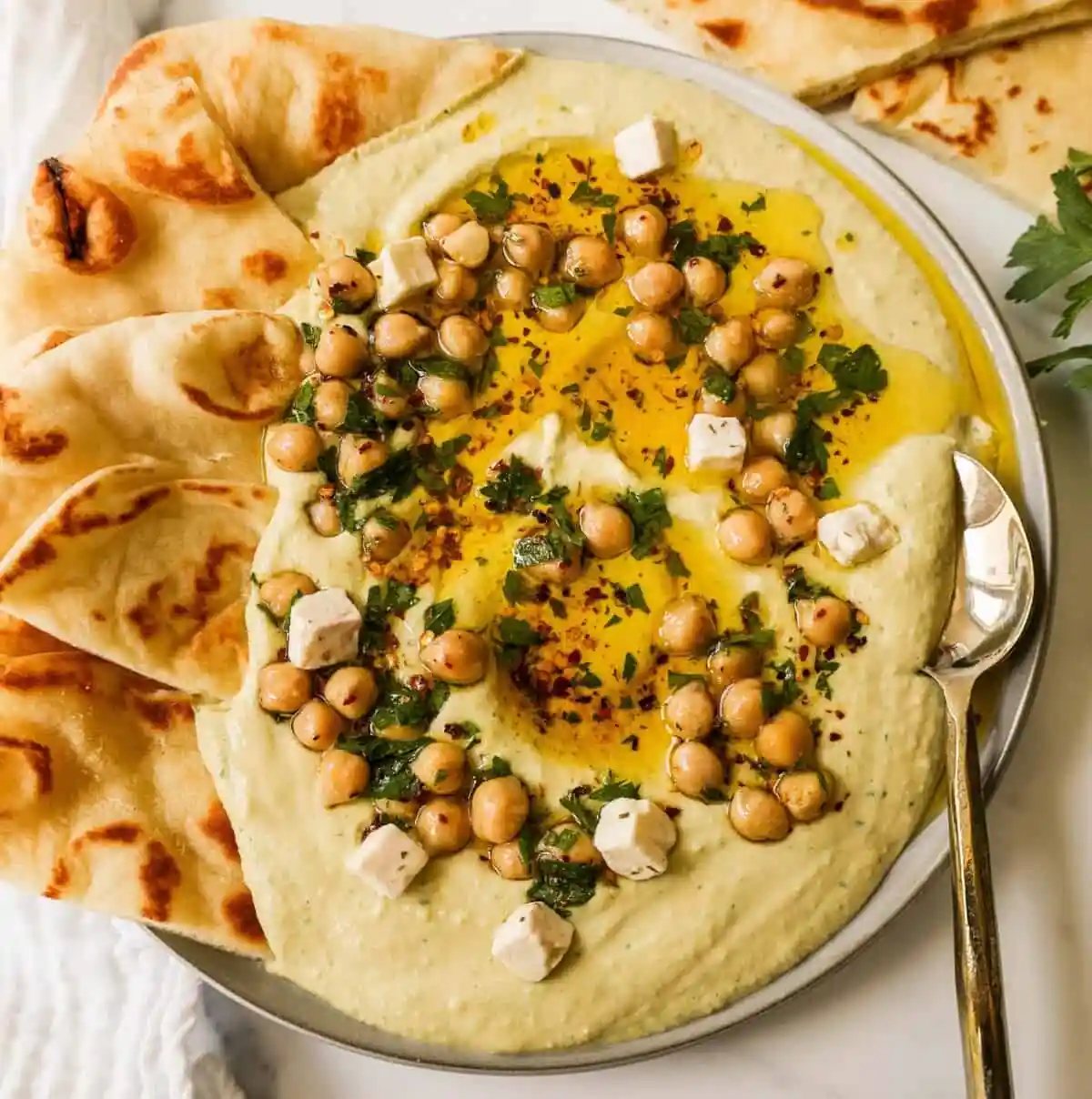 How to make authentic, creamy, homemade hummus made from scratch using simple ingredients -- chickpeas, tahini, garlic, olive oil, lemon juice, and salt. This is such an easy hummus recipe that everyone will love!