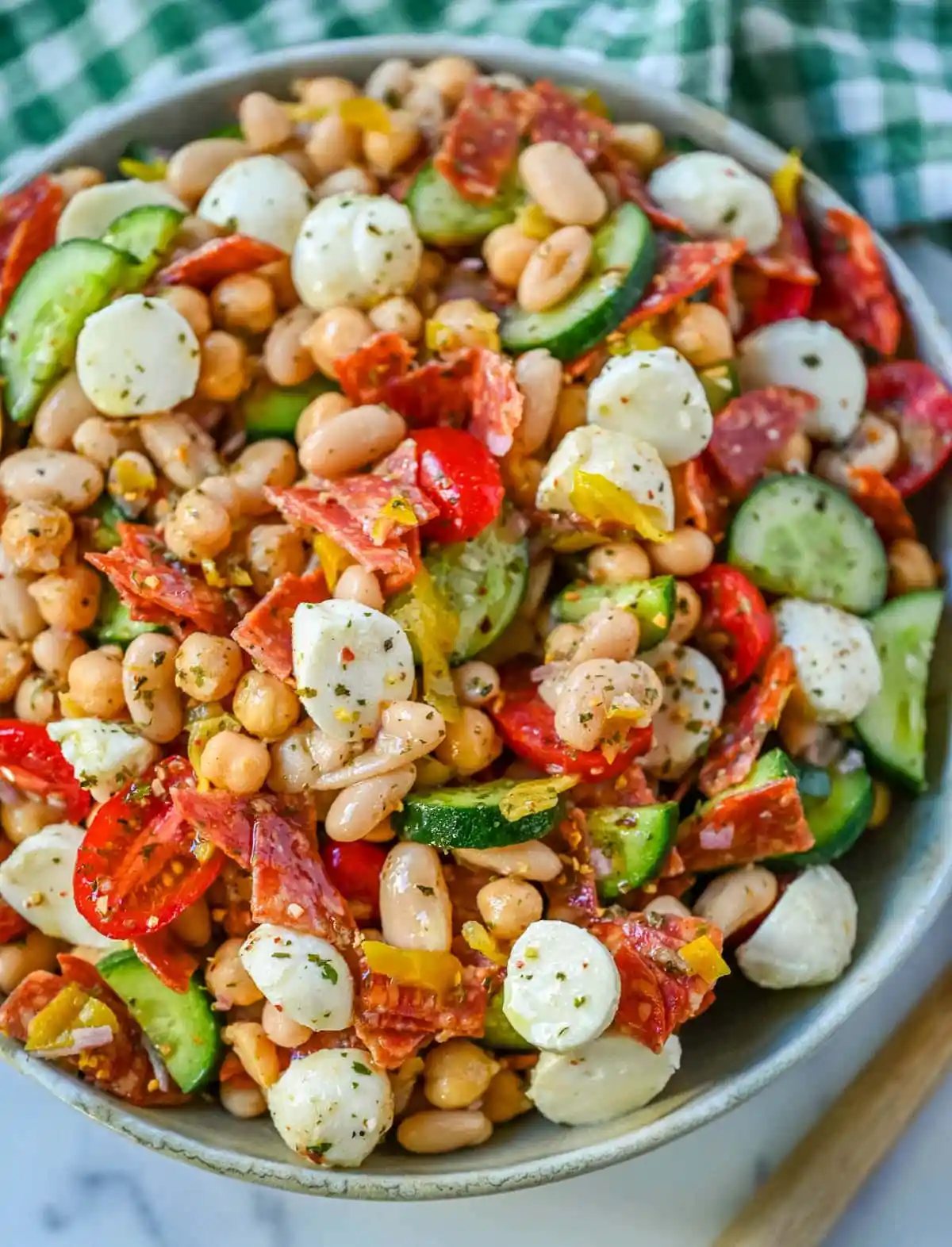 This Italian dense bean salad is the TikTok viral high protein meal prep recipe that has taken over the internet and for very good reason. Loaded with chickpeas, white beans, crisp Persian cucumbers, cherry tomatoes, creamy mozzarella, savory pepperoni or salami, and tangy pepperoncinis all tossed in a homemade Italian dressing, every single bite is packed with incredible flavor that gets better the longer it sits.