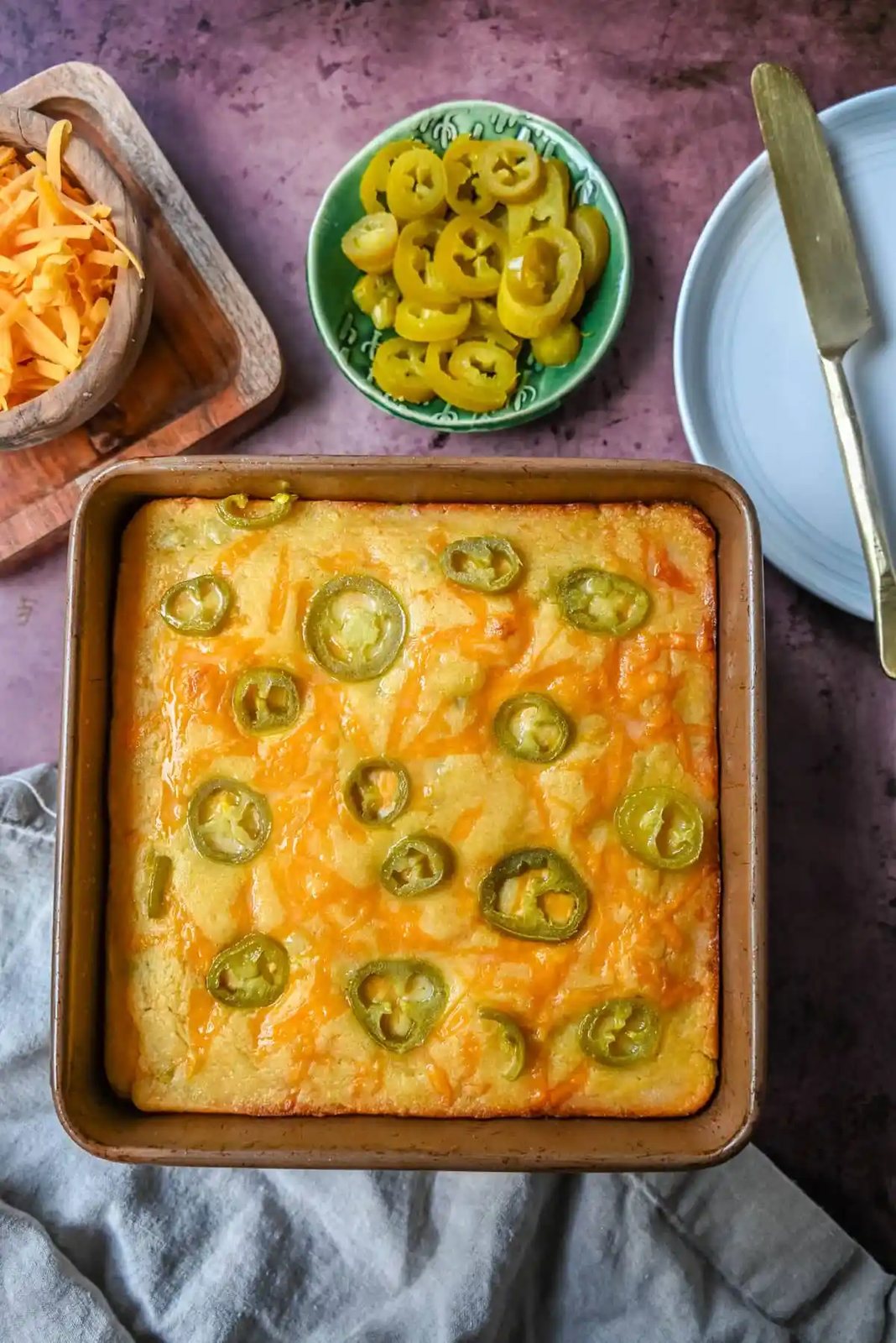 This Homemade Jalapeno Cheddar Cornbread is golden, cheesy, spicy, and just a little sweet, and is the ultimate upgrade from basic boxed cornbread. It has a moist, fluffy center amd layered with sharp cheddar cheese and jalapenos for the perfect Jalapeno Cheddar Cornbread recipe.