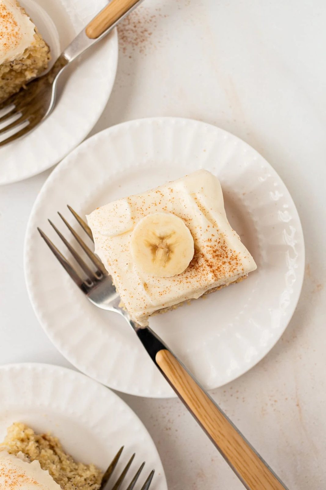 Banana Cake with cream cheese frosting cut into squares.