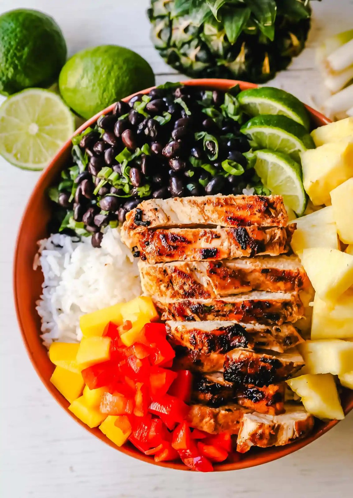 Jerk Chicken Bowl Jamaican spiced grilled Jerk Chicken with rice, black beans, cilantro, fresh pineapple and mango, and red peppers. www.modernhoney.com #jerkchicken #chicken #chickenbowl