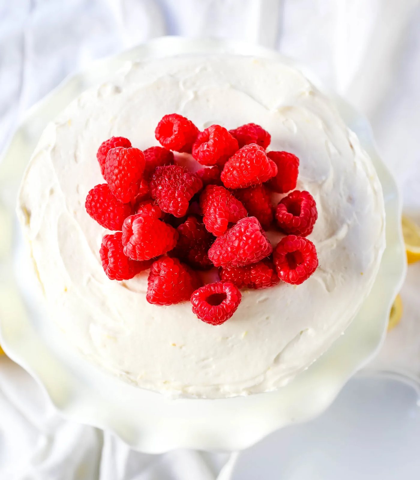 The Best Lemon Raspberry Cake. A light and fluffy lemon cake with fresh raspberries and a fresh lemon cream cheese frosting. A sweet and tangy lemon berry cake! #lemoncake #cake #lemonraspberrycake
