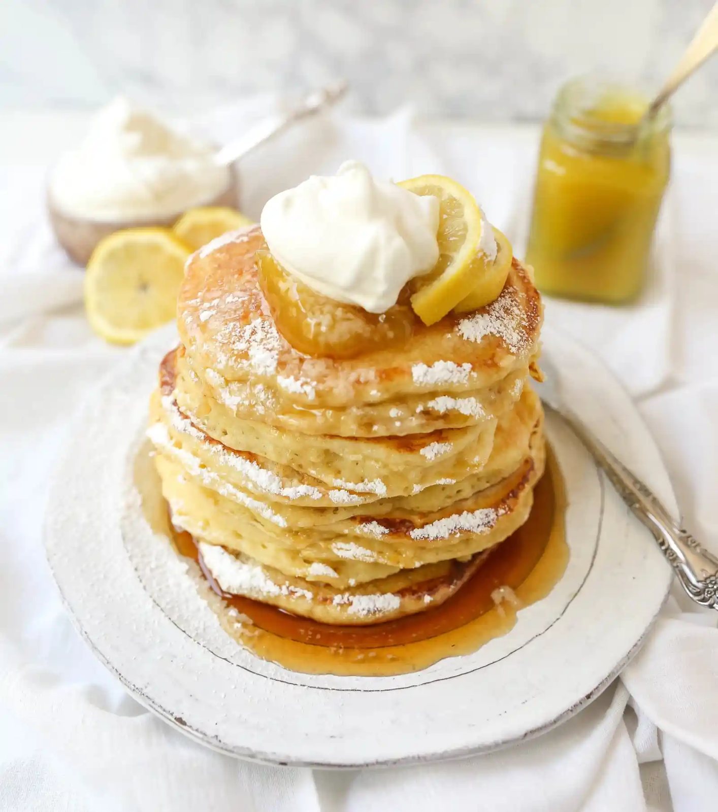 Lemon Ricotta Pancakes Creamy, fluffy lemon ricotta pancakes made with fresh ricotta, buttermilk, fresh lemon zest, and juice. A mix between a pancake and a crepe with a melt-in-your-mouth soft texture. www.modernhoney.com #pancakes #lemonricottapancakes #brunch #breakfast