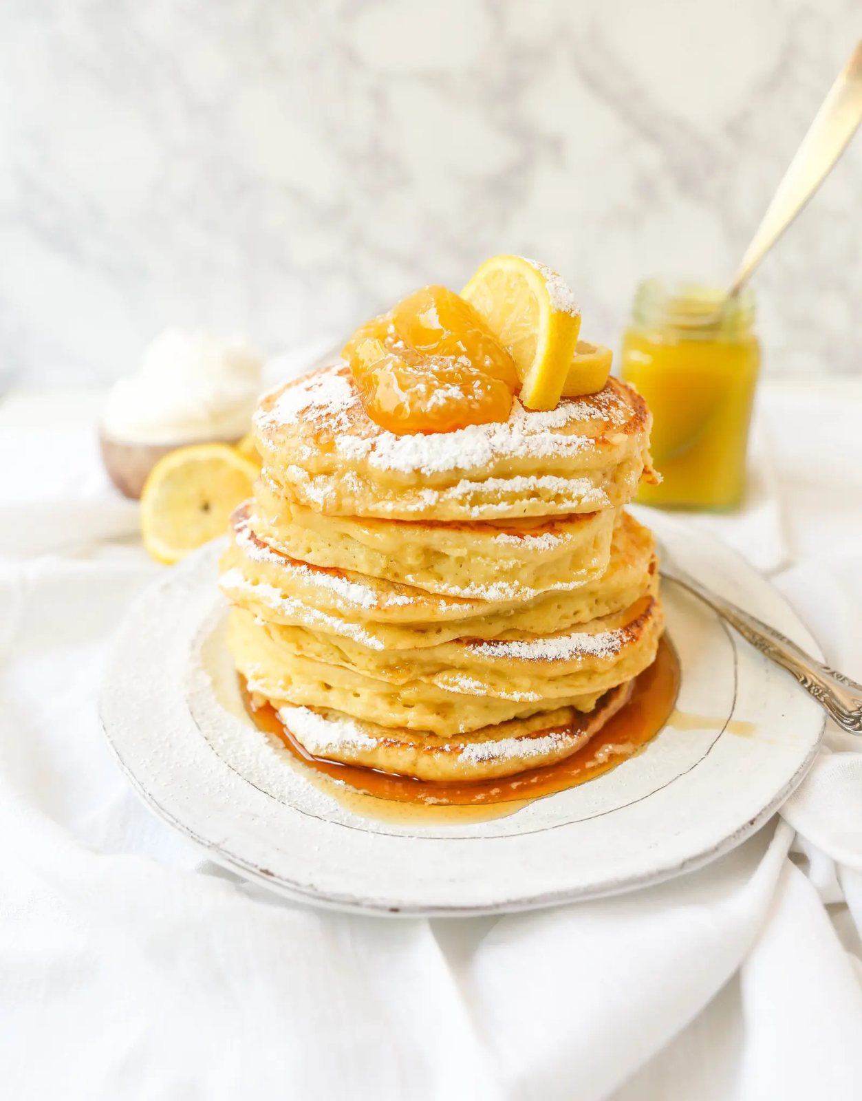 Lemon Ricotta Pancakes Creamy, fluffy lemon ricotta pancakes made with fresh ricotta, buttermilk, fresh lemon zest, and juice. A mix between a pancake and a crepe with a melt-in-your-mouth soft texture. www.modernhoney.com #pancakes #lemonricottapancakes #brunch #breakfast