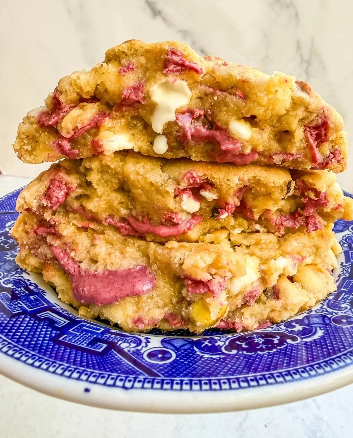 These Levain Bakery Raspberry Pistachio cookies are a homemade copycat of Levain Bakery's new summer flavor, which combines raspberry chips, crunchy pistachios, and creamy white chocolate chips in their signature thick, bakery-style cookie. Our version uses a homemade raspberry chip made from crushed freeze-dried raspberries and white chocolate for that same fruity flavor without needing specialty baking chips. These cookies are thick, gooey, and loaded with tart raspberry, rich white chocolate, and crunchy salted pistachios in every bite!