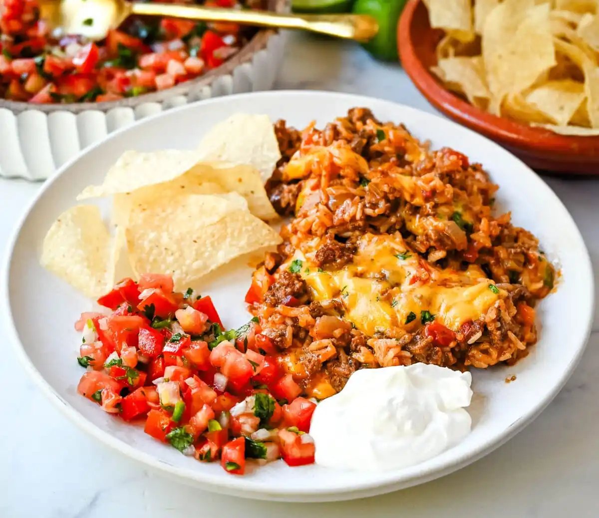 This Cheesy Taco Rice Skillet is a hearty, one-pan meal that brings all your favorite Tex-Mex flavors together in under 30 minutes. This Mexican Taco Skillet is loaded with seasoned ground beef, uncooked rice, and diced tomatoes—then simmered in a savory blend of beef broth and spices until perfectly tender and topped with melted cheese. A total crowd-pleaser for families and busy weeknights.