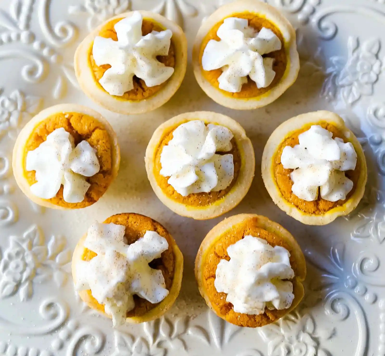 Mini Pumpkin Pie Bites. The best bite-size mini pumpkin pies perfect for entertaining during the holiday season. Creamy pumpkin pie filling in buttery pie crust cups topped with fresh whipped cream. www.modernhoney.com #pumpkinpie #pumpkinpiebites #minipumpkinpies