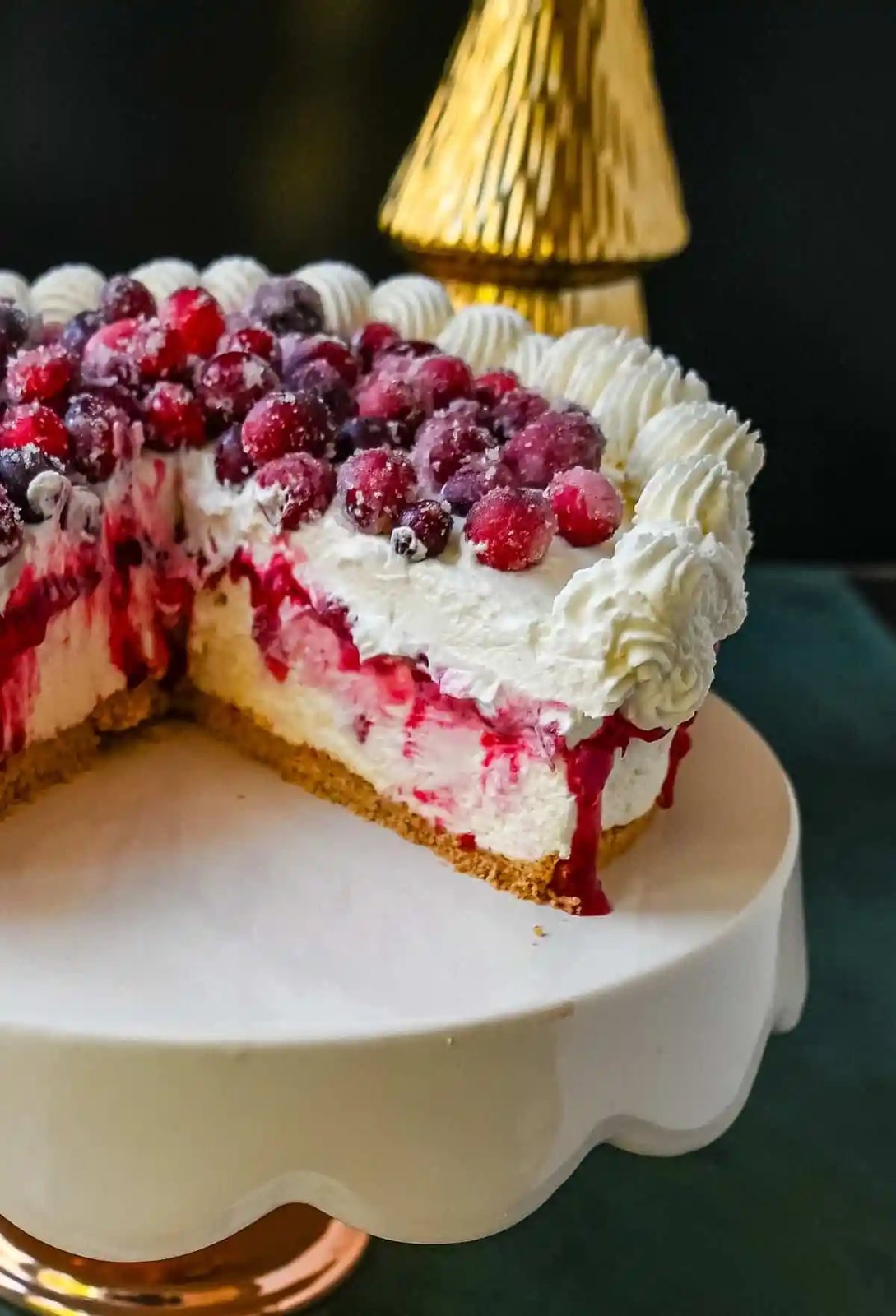 No-Bake Cranberry White Chocolate Cheesecake. This is a beautiful Christmas Cranberry Cheesecake perfect for the holidays. This no-bake white chocolate cheesecake has a graham cracker crust, white chocolate cream cheese filling, topped with homemade cranberry jam, sugared cranberries, and whipped cream.