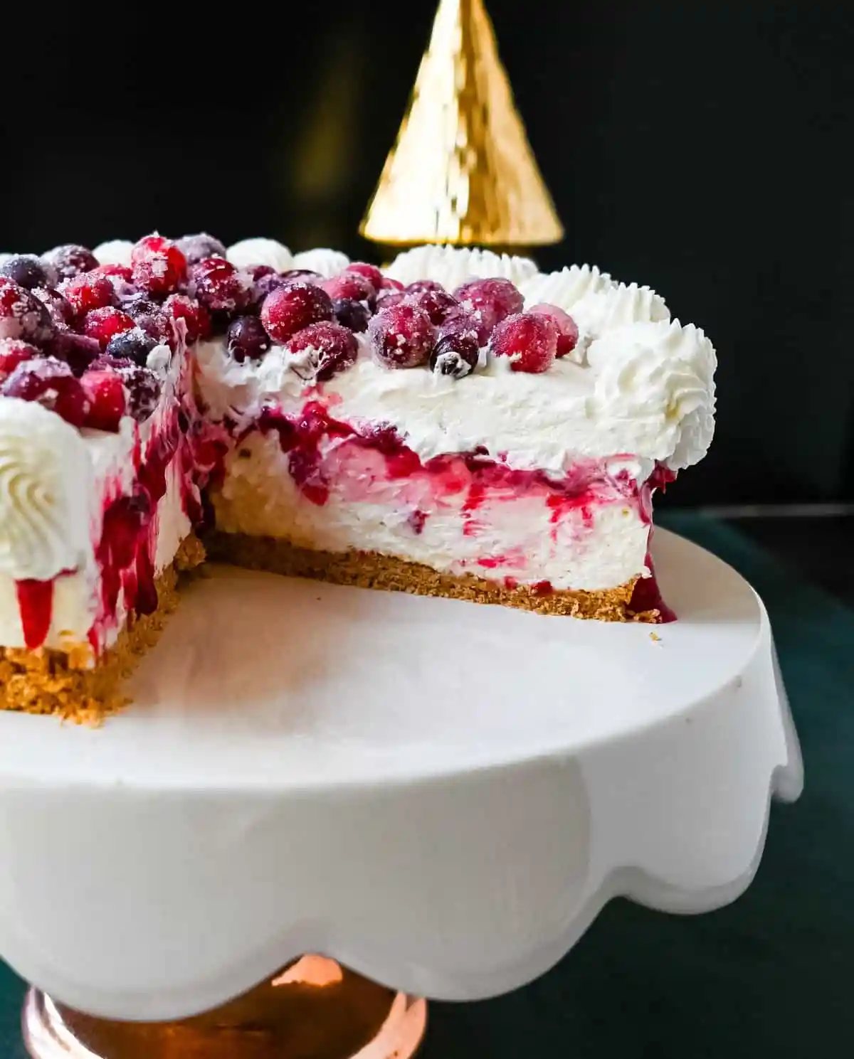 No-Bake Cranberry White Chocolate Cheesecake. This is a beautiful Christmas Cranberry Cheesecake perfect for the holidays. This no-bake white chocolate cheesecake has a graham cracker crust, white chocolate cream cheese filling, topped with homemade cranberry jam, sugared cranberries, and whipped cream.