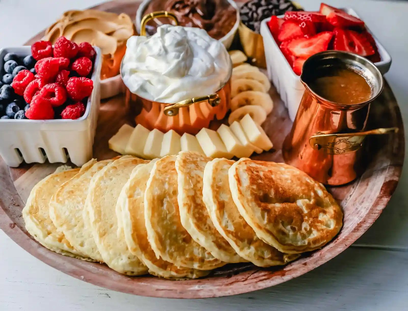 Breakfast Pancake Board. The perfect breakfast for entertaining! Homemade buttermilk pancakes topped with all of your favorite toppings -- fresh berries, whipped cream, homemade syrup, Nutella, chocolate chips, peanut butter, and more.