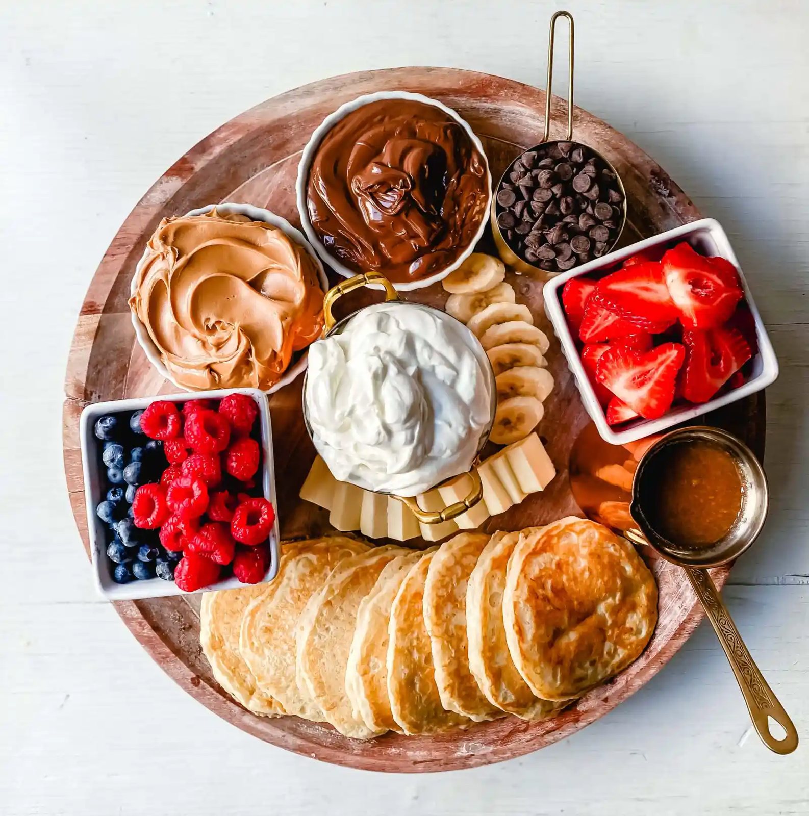 Breakfast Pancake Board. The perfect breakfast for entertaining! Homemade buttermilk pancakes topped with all of your favorite toppings -- fresh berries, whipped cream, homemade syrup, Nutella, chocolate chips, peanut butter, and more.