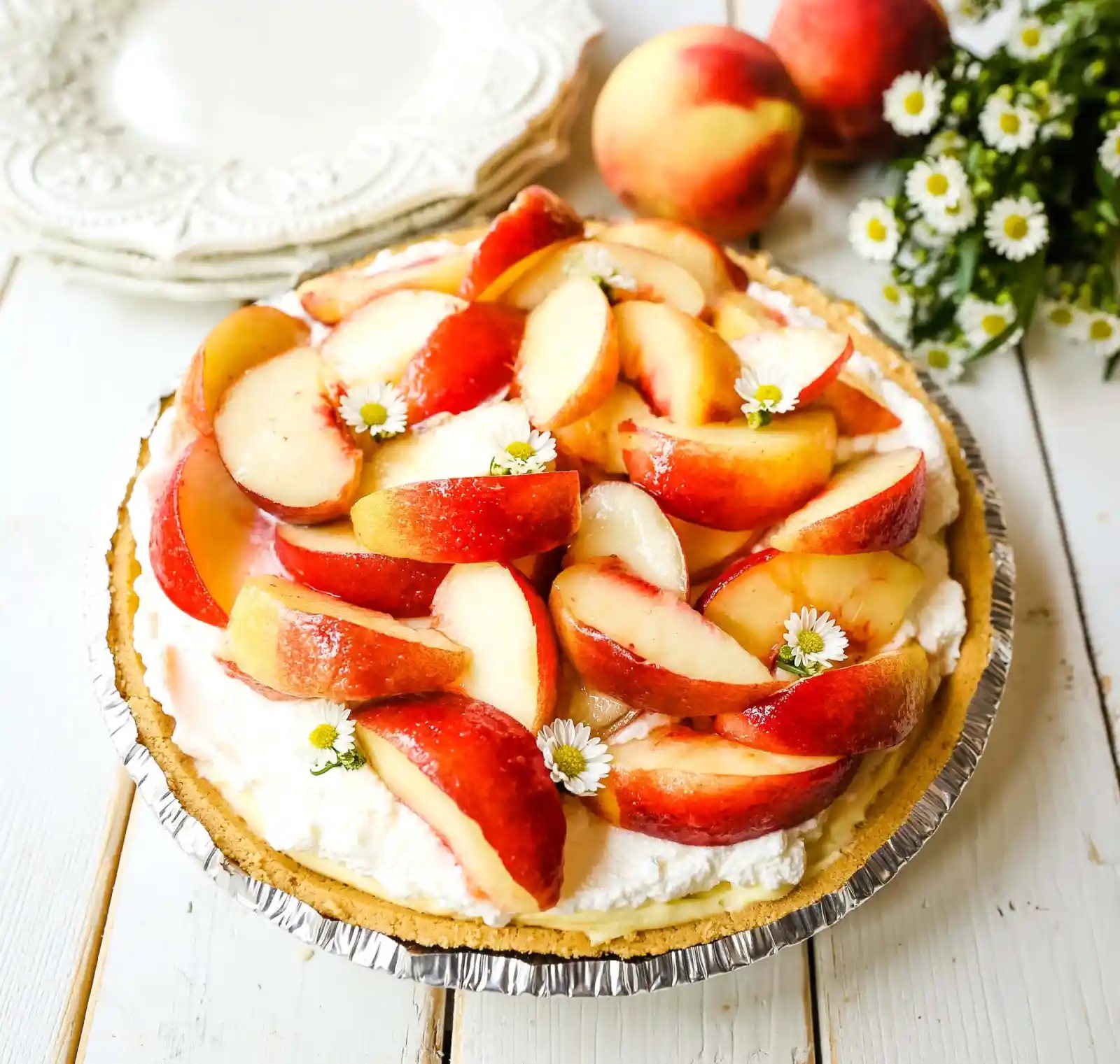 Peaches and Cream Pie. A quick and easy no-bake creamy peach pie with a buttery graham cracker crust, a sweet custard filling, fresh whipped cream, and sliced peaches. www.modernhoney.com #pie #nobakedessert #nobakepie #peachdessert #peaches #peach