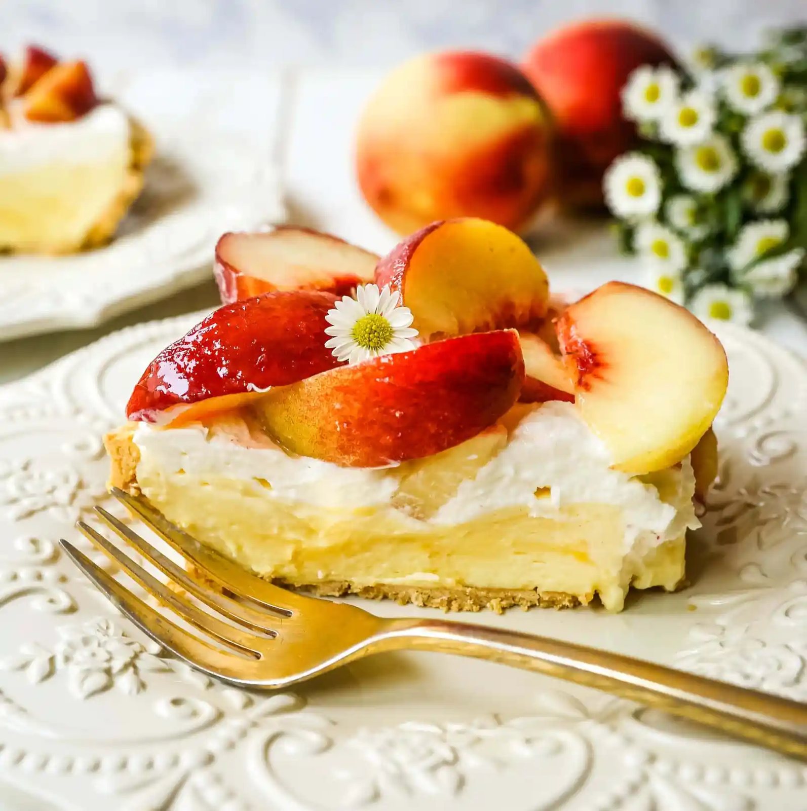 Peaches and Cream Pie. A quick and easy no-bake creamy peach pie with a buttery graham cracker crust, a sweet custard filling, fresh whipped cream, and sliced peaches. www.modernhoney.com #pie #nobakedessert #nobakepie #peachdessert #peaches #peach