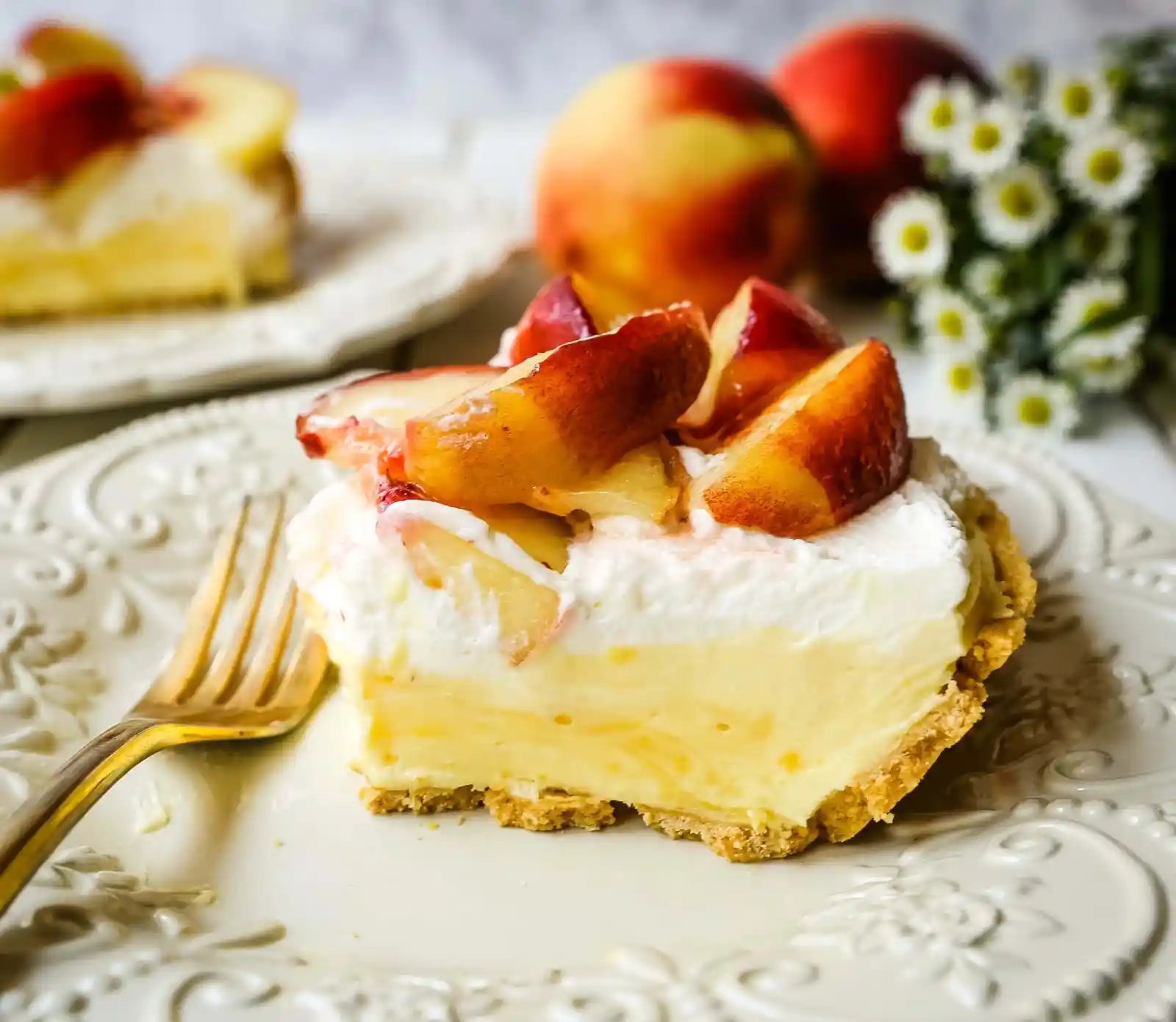 Peaches and Cream Pie. A quick and easy no-bake creamy peach pie with a buttery graham cracker crust, a sweet custard filling, fresh whipped cream, and sliced peaches. www.modernhoney.com #pie #nobakedessert #nobakepie #peachdessert #peaches #peach