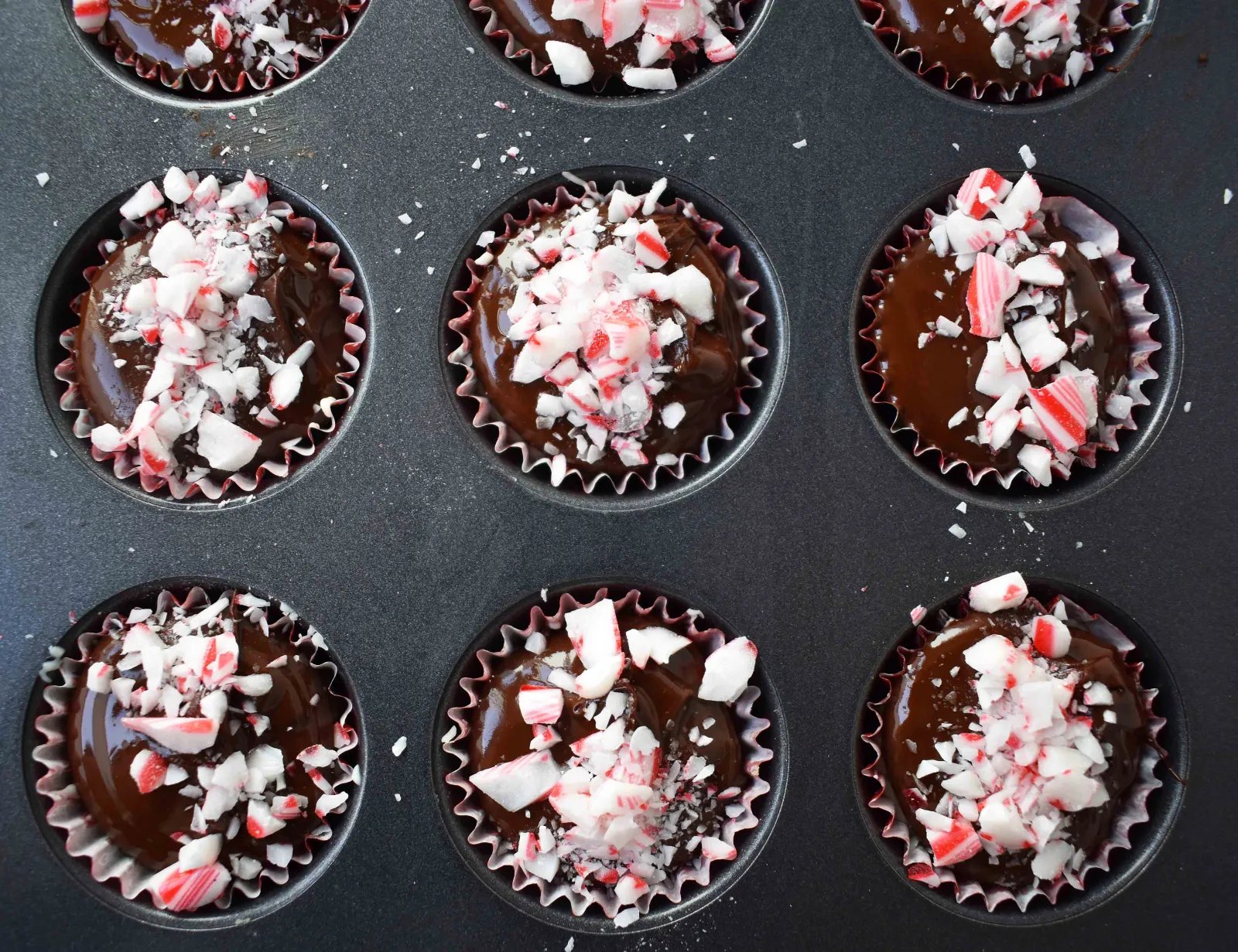 Peppermint Bark Cookie Dough Cups by Modern Honey. Egg Free Chocolate Chip Cookie Dough layered with white chocolate and semisweet chocolate and topped with crushed candy canes.