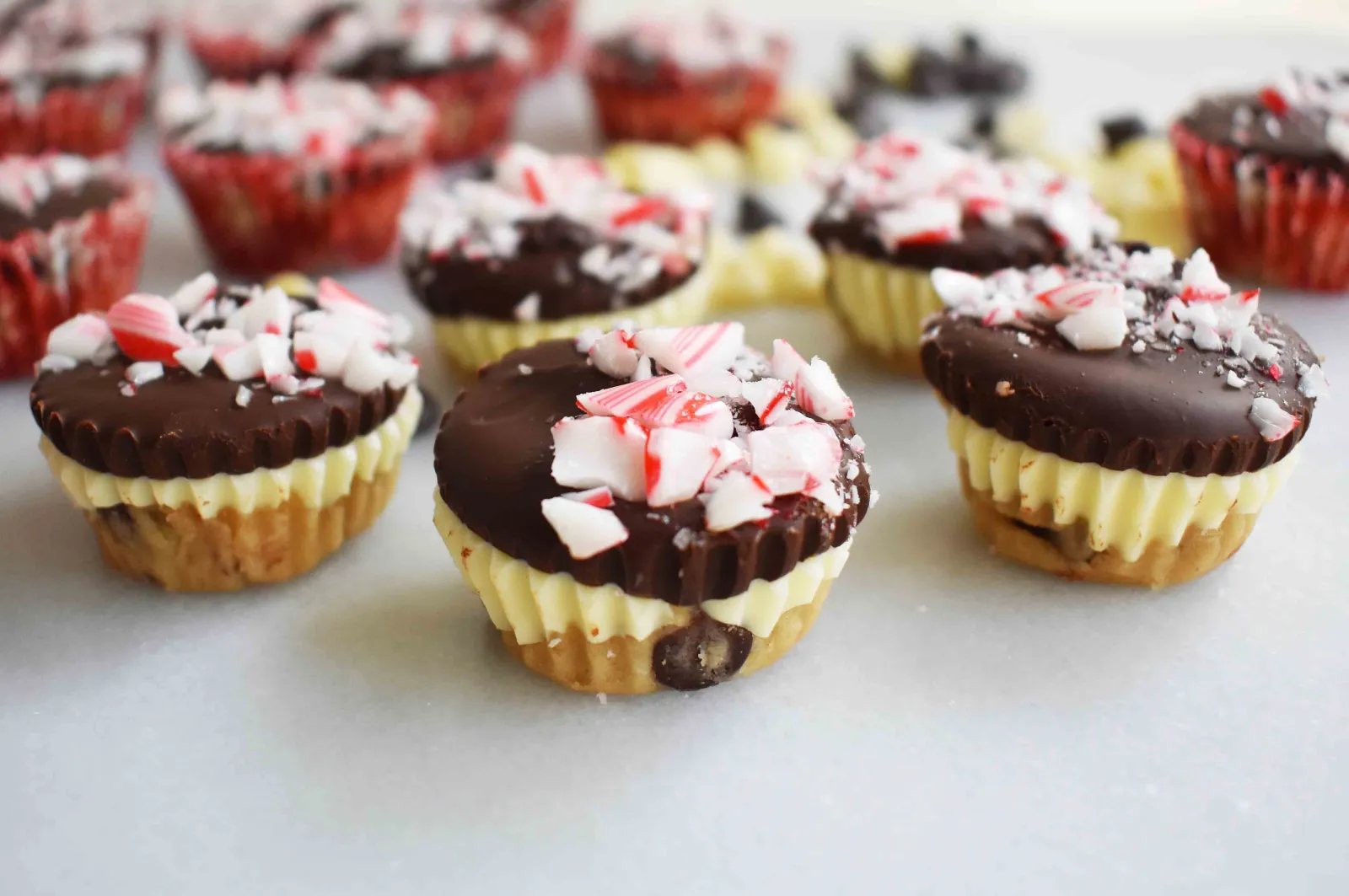 Peppermint Bark Cookie Dough Cups by Modern Honey. Egg Free Chocolate Chip Cookie Dough layered with white chocolate and semisweet chocolate and topped with crushed candy canes.