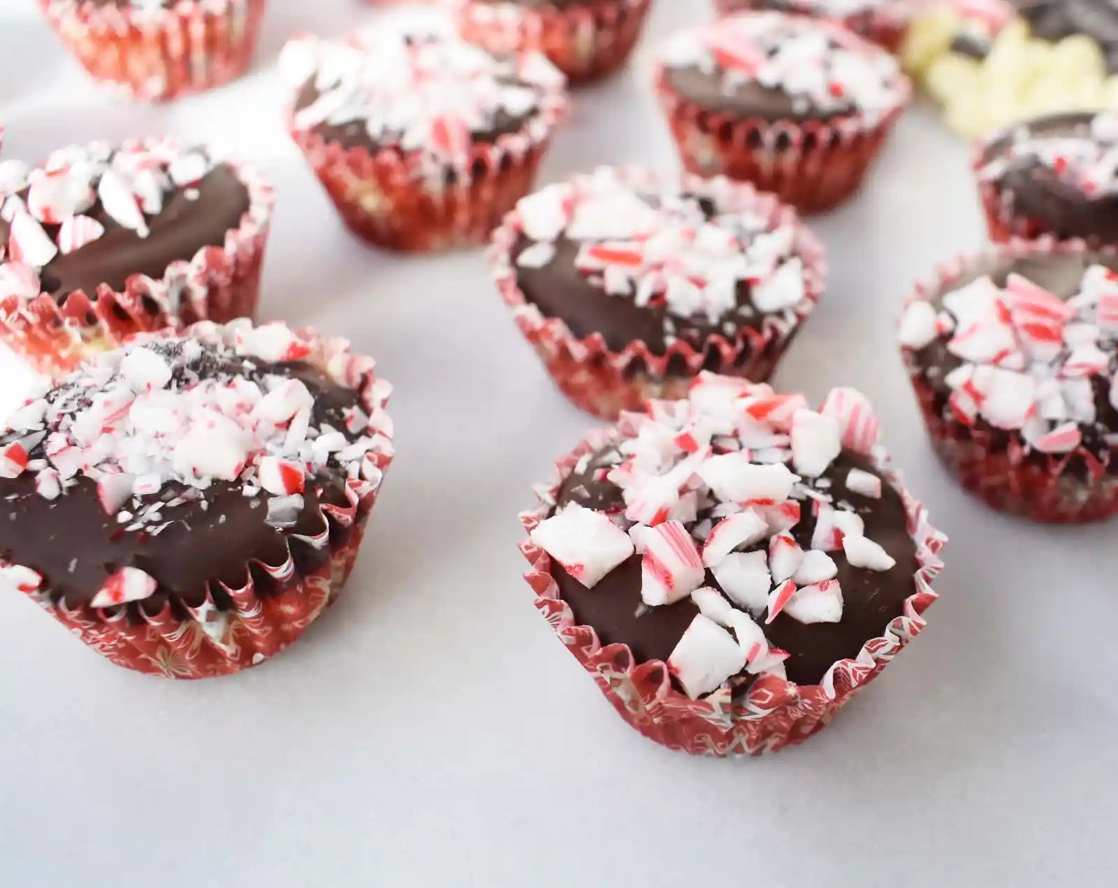 Peppermint Bark Cookie Dough Cups by Modern Honey. Egg Free Chocolate Chip Cookie Dough layered with white chocolate and semisweet chocolate and topped with crushed candy canes.