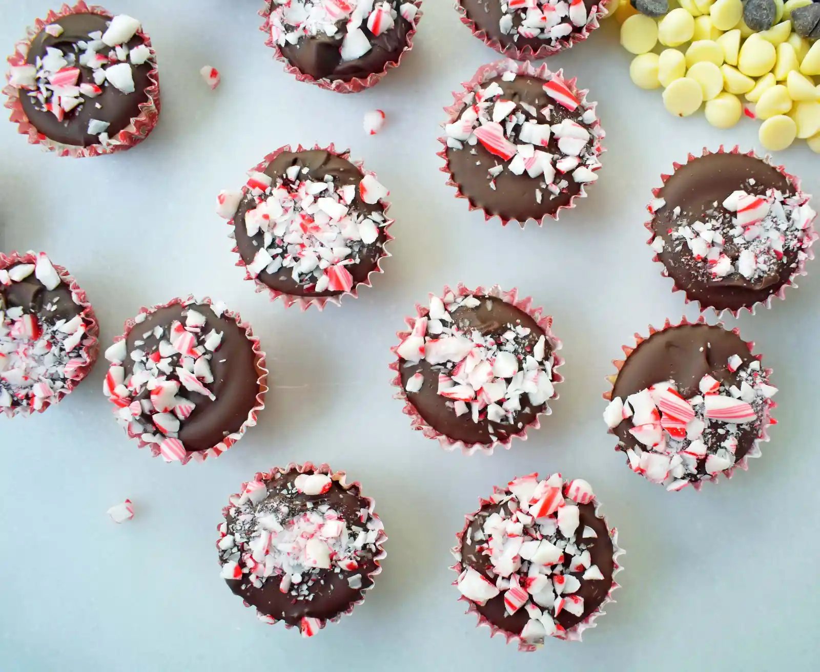 Peppermint Bark Cookie Dough Cups by Modern Honey. Egg Free Chocolate Chip Cookie Dough layered with white chocolate and semisweet chocolate and topped with crushed candy canes.