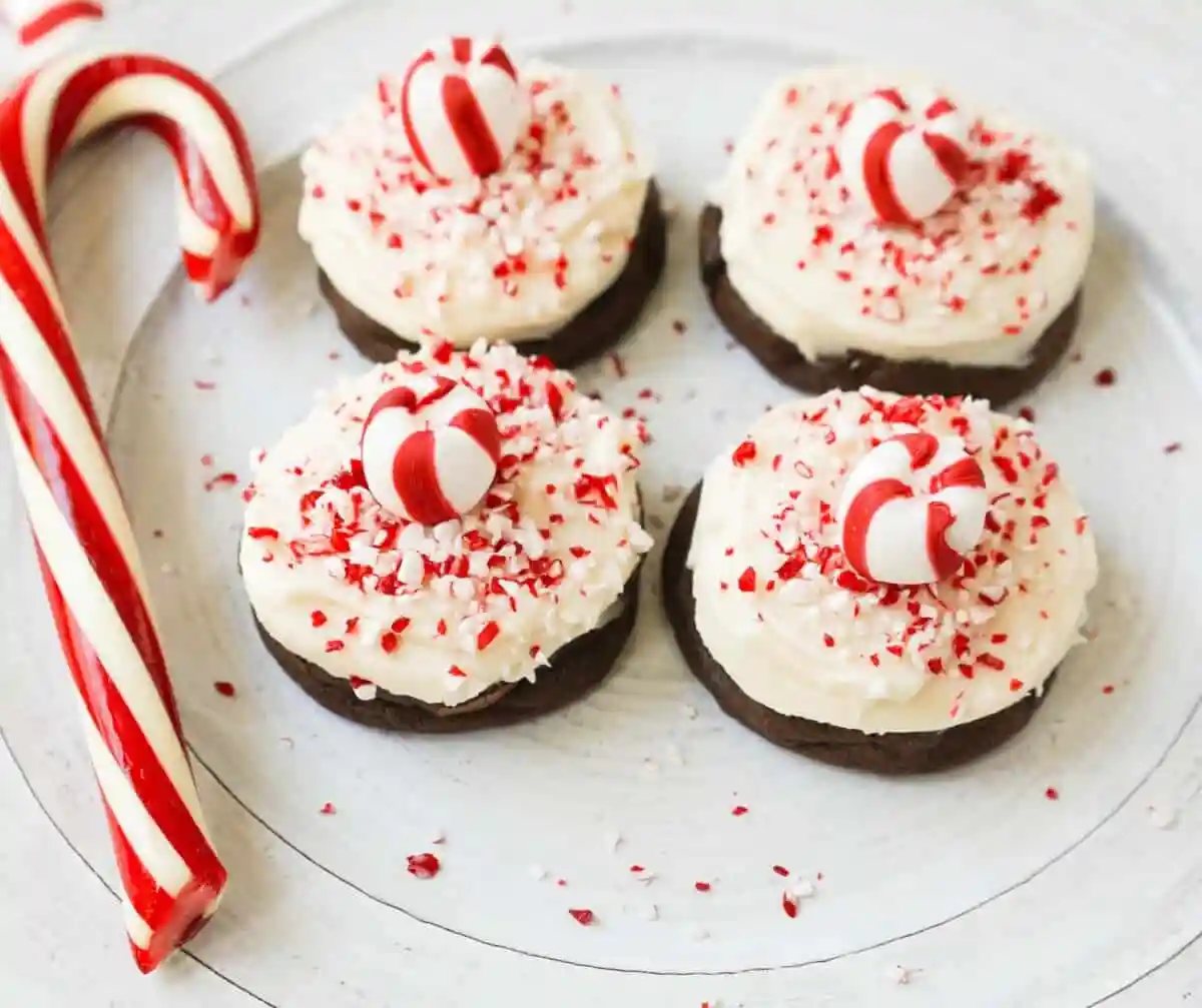 Soft, decadent chocolate cookies topped with homemade creamy peppermint frosting and crushed candy canes. The perfect peppermint frosted chocolate cookie recipe! A delicious peppermint and chocolate Christmas cookie.