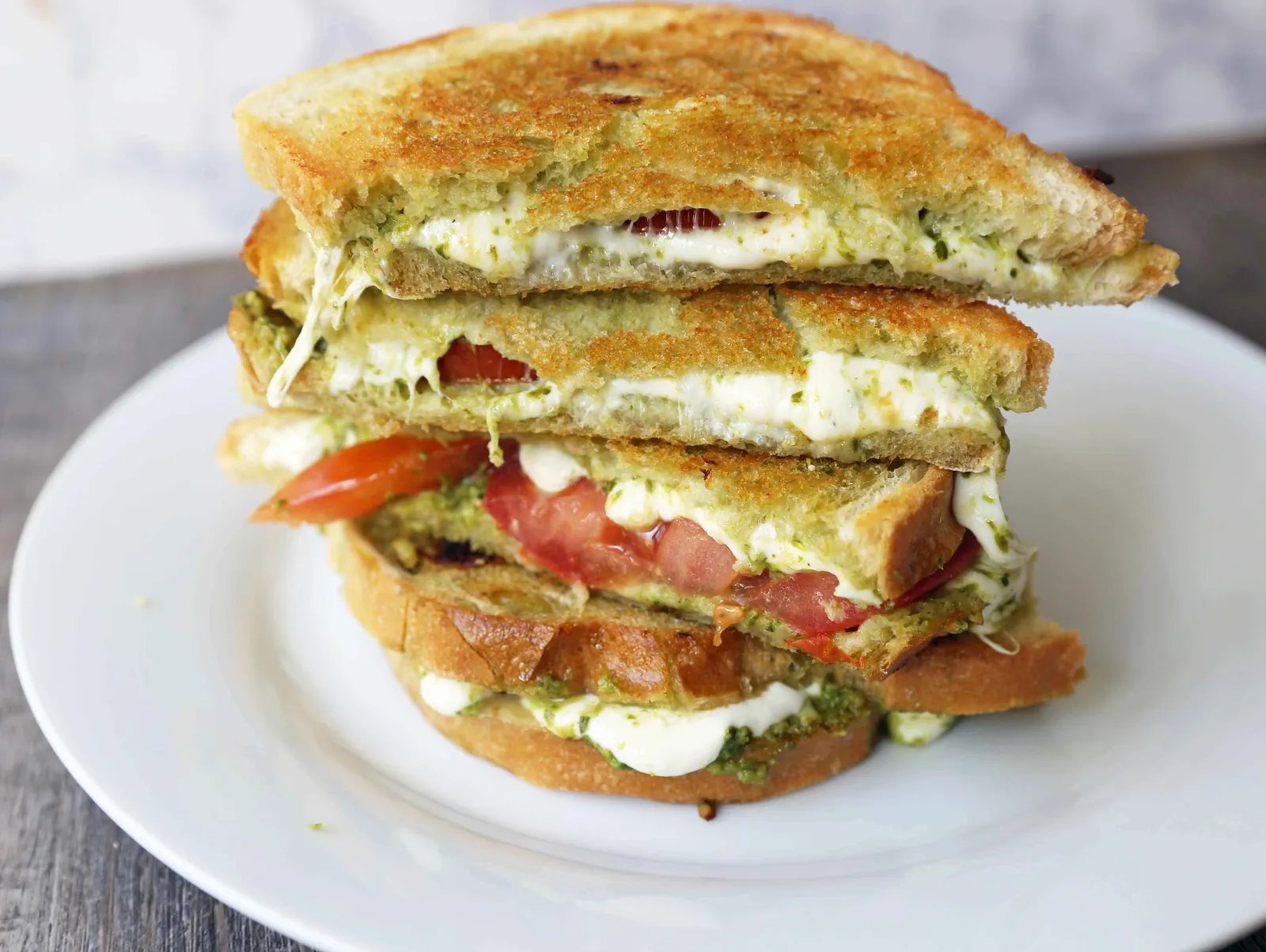 Pesto Panini with Fresh Mozzarella and Tomato. A toasted buttery panini with basil pesto, melted fresh mozzarella cheese, and juicy tomatoes. www.modernhoney.com #panini #sandwich #pesto #grilledsandwich