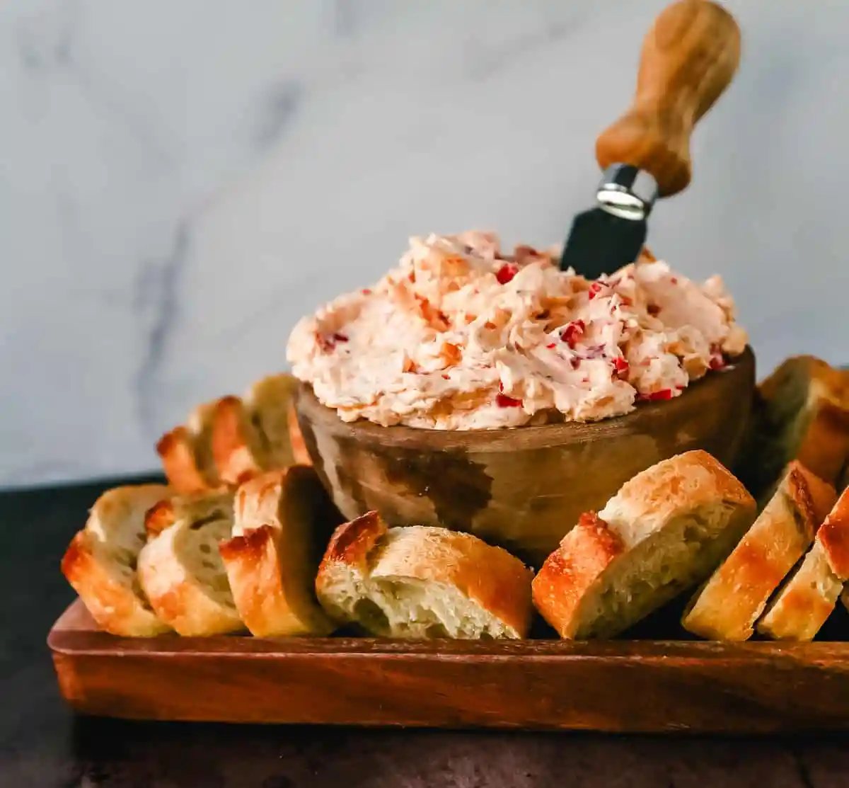 This pimento cheese dip is famous in the South for good reason. This pimento dip is made with cream cheese, mayonnaise, two types of cheddar cheeses, chopped pimentos, cayenne pepper, and a touch of salt.