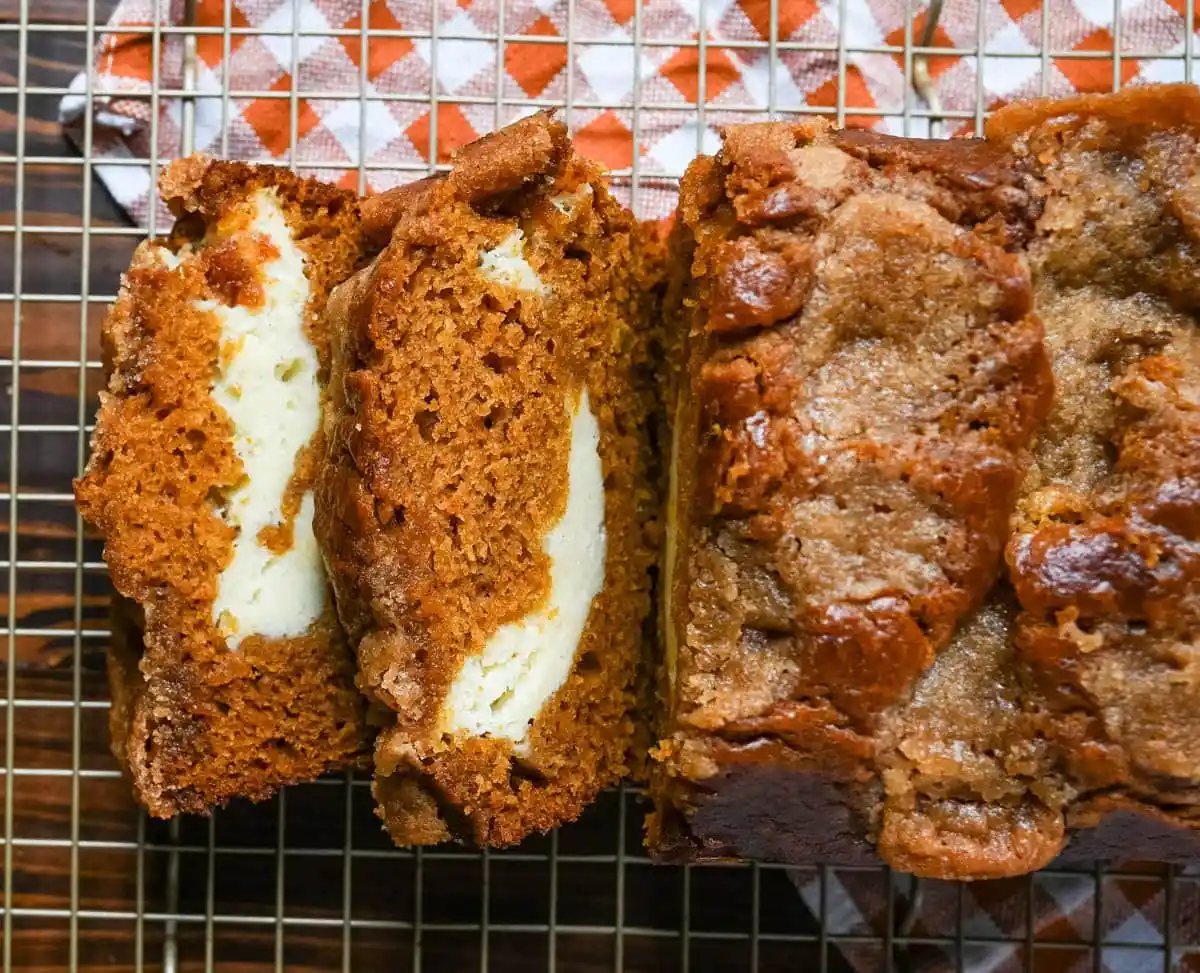 This pumpkin cream cheese bread has a thick ribbon of tangy cheesecake running through the middle, a buttery brown sugar streusel on top, and one simple trick that gives it the deepest, richest pumpkin flavor you've had in a loaf. This is the best pumpkin cream cheese bread recipe and it makes two loaves.