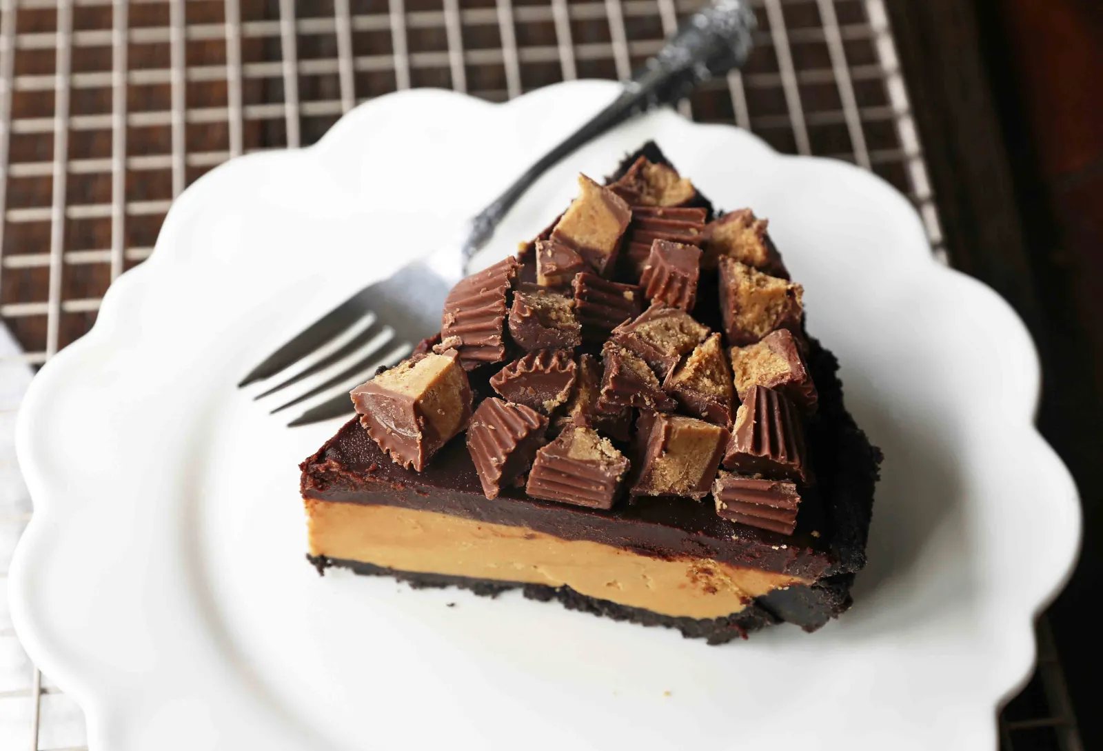 Chocolate Peanut Butter Cup Pie. Homemade chocolate peanut butter pie with an OREO cookie crust, creamy peanut butter mousse filling, and topped with chocolate ganache and peanut butter cups. www.modernhoney.com #peanutbutter #chocolatepeanutbutter #pie #pies #pierecipe