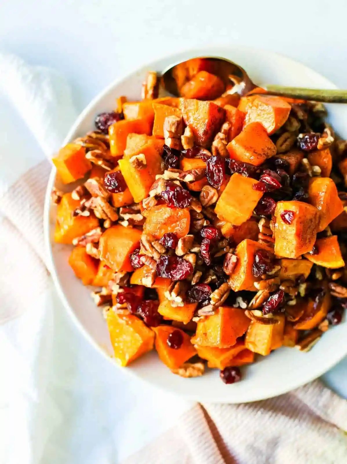 Roasted Sweet Potatoes with Cinnamon Maple Drizzle and tossed with dried cranberries and pecans. The perfect Fall side dish recipe! These roasted sweet potatoes make a beautiful Thanksgiving side dish.
