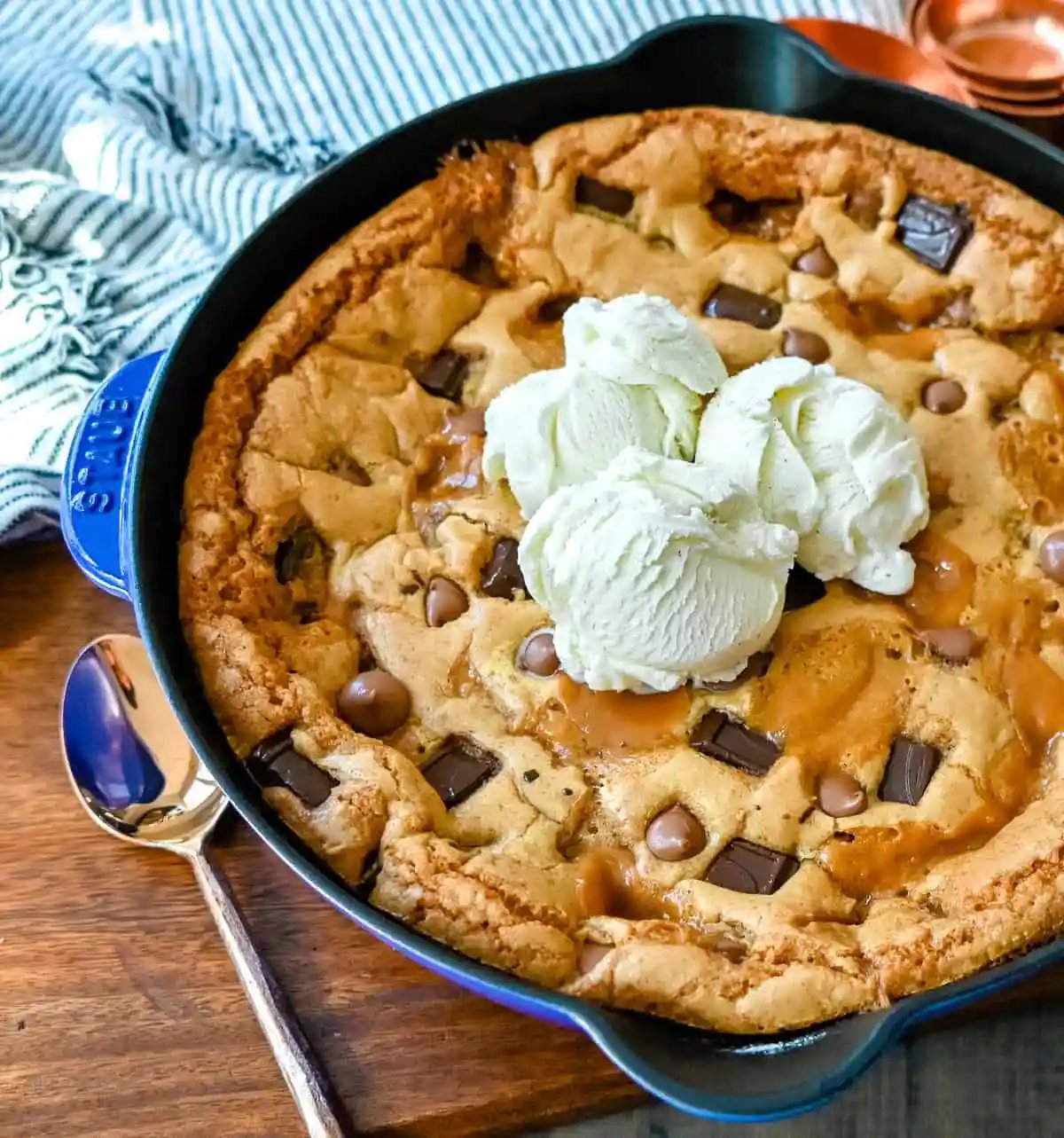 This salted caramel chocolate skillet cookie baked in a cast iron skillet and topped with vanilla ice cream has the perfect combination of sweet and salty caramel, and decadent chocolate in a perfectly buttery cookie.