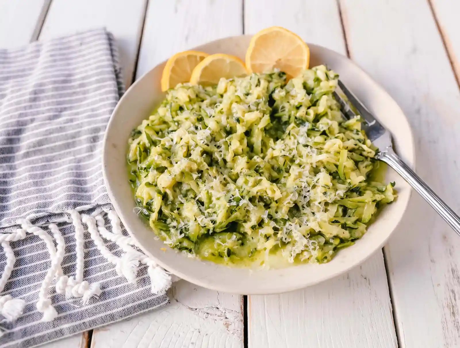 Shredded Sautéed Zucchini with Parmesan. Simple shredded fresh zucchini sauteed until tender and topped with salt, pepper, garlic, and parmesan cheese. This zucchini recipe pairs so well with beef and chicken. #zucchini #sidedish #vegetables