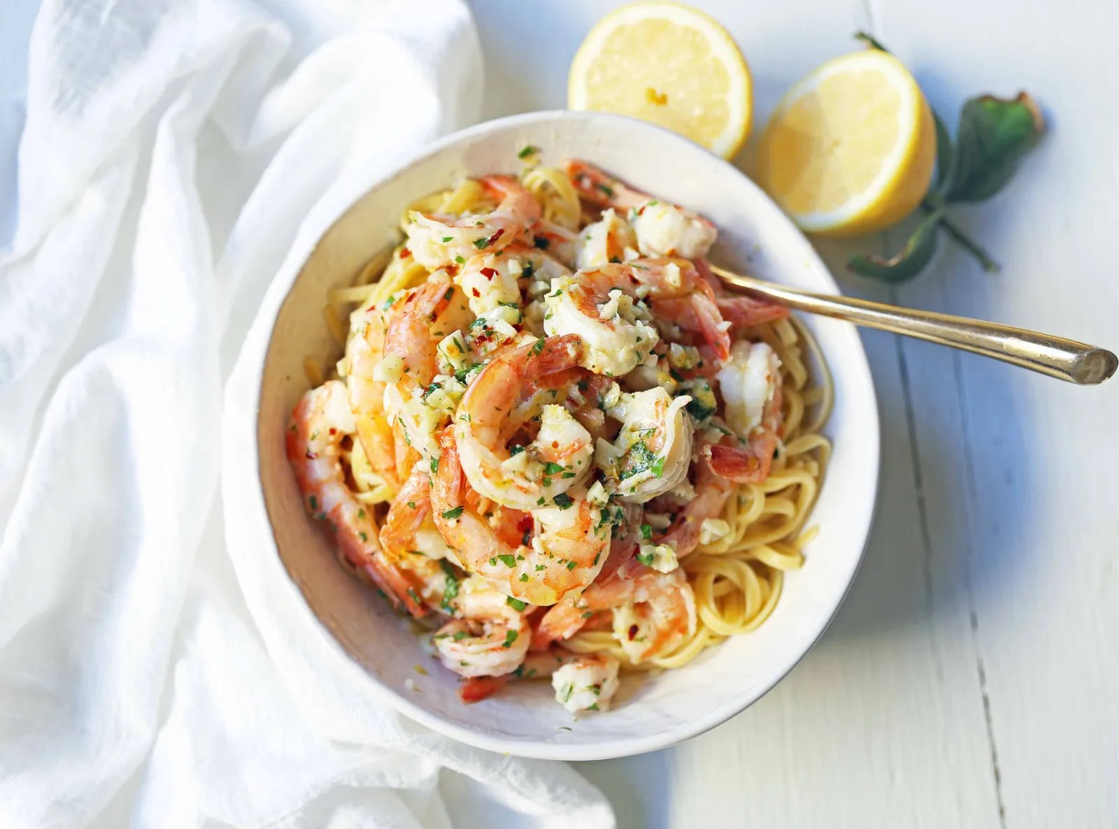 Shrimp Scampi Linguine. Shrimp sauteed in a lemon garlic butter sauce tossed with linguine pasta and made in less than 20 minutes. www.modernhoney.com #shrimp #shrimpscampi #shrimpscampilinguine #pasta #valentinesday