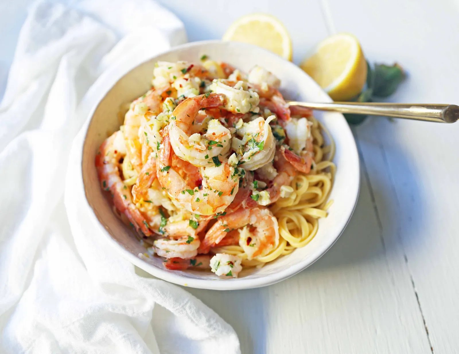 Shrimp Scampi Linguine. Shrimp sauteed in a lemon garlic butter sauce tossed with linguine pasta and made in less than 20 minutes. www.modernhoney.com #shrimp #shrimpscampi #shrimpscampilinguine #pasta #valentinesday