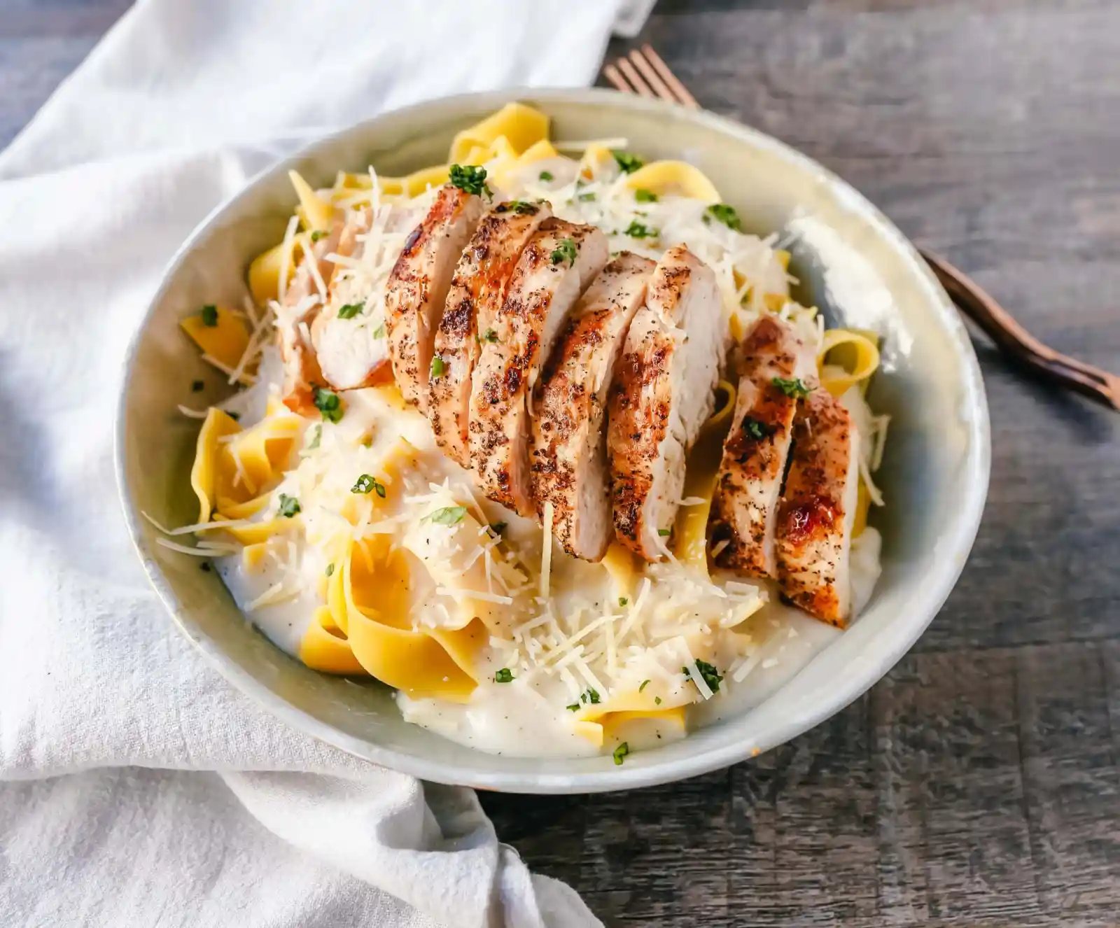 Skinny Low-Fat Chicken Fettuccine Alfredo All of the flavor of Chicken Fettuccine Alfredo without all of the fat and calories! Lean grilled chicken on top of low-fat alfredo sauce tossed with fettuccine noodles. www.modernhoney.com #lowfat #chicken #pasta