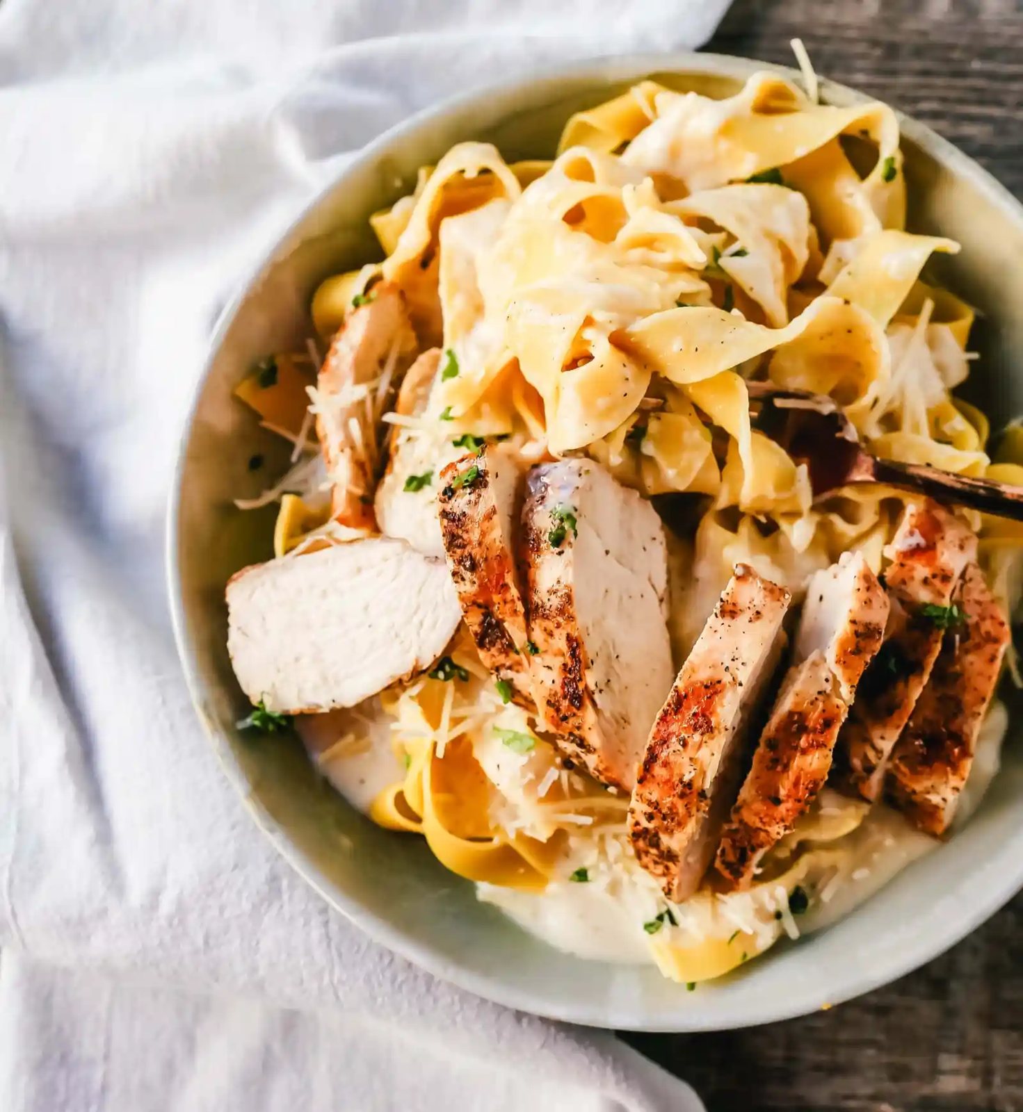 Skinny Low-Fat Chicken Fettuccine Alfredo All of the flavor of Chicken Fettuccine Alfredo without all of the fat and calories! Lean grilled chicken on top of low-fat alfredo sauce tossed with fettuccine noodles. www.modernhoney.com #lowfat #chicken #pasta
