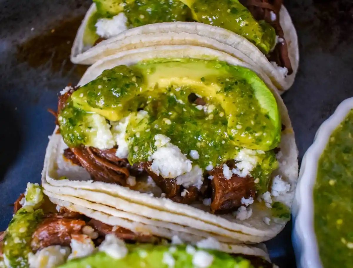Slow Cooker Beef Barbacoa Tacos with Salsa Verde. These Barbacoa Beef Tacos with Tomatillo Salsa are made with slow cooked, Mexican spiced beef inside fresh corn tortillas and topped with homemade salsa verde, Mexican cheese, and fresh avocado. An easy and flavorful beef tacos recipe!