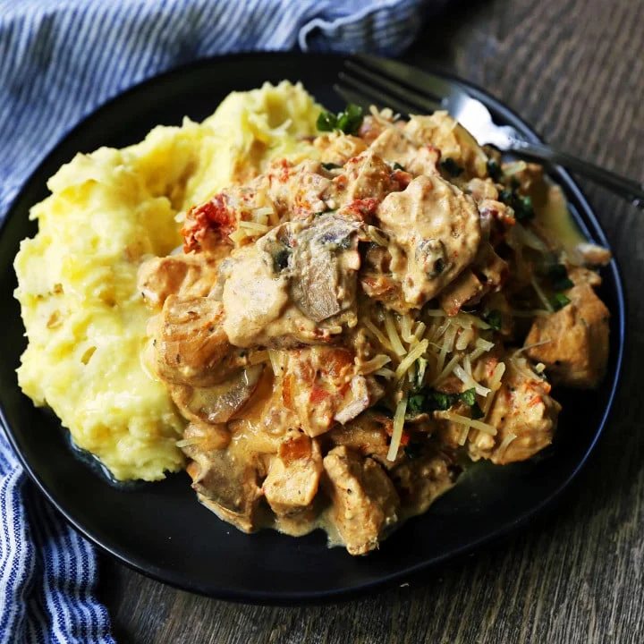 Slow Cooker Creamy Tuscan Chicken. Creamy tender chicken in prosciutto, mushroom, and sundried tomato cream sauce. Comfort food made in a slow cooker. www.modernhoney.com #dinner #slowcooker #slowcookerchicken #chickendinnerrecipes #creamychicken