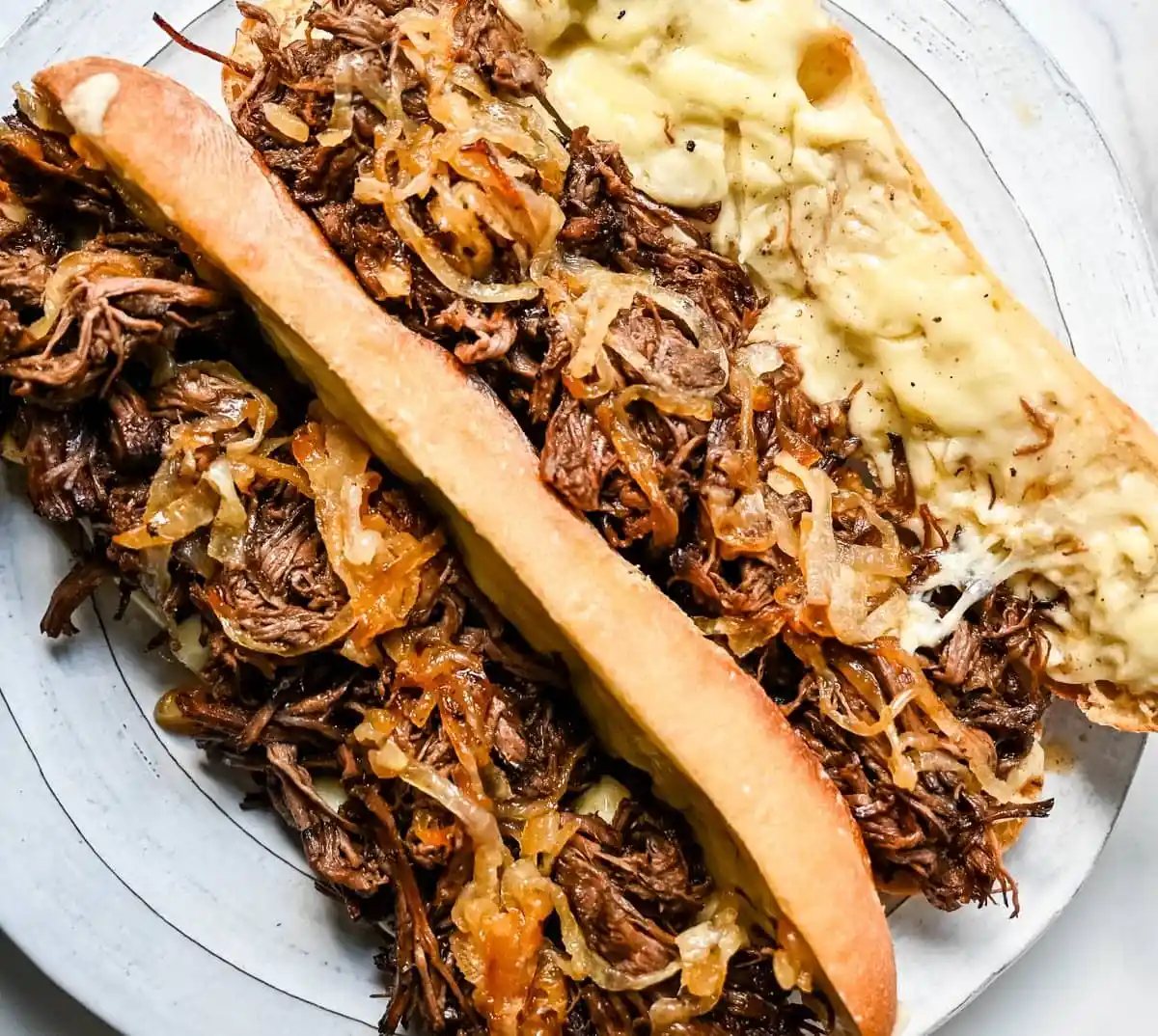 This easy slow cooker French dip sandwich recipe features tender beef, savory au jus, caramelized onions, and melted provolone cheese. Finished with a creamy horseradish aioli, it’s a restaurant-quality sandwich made right at home.
