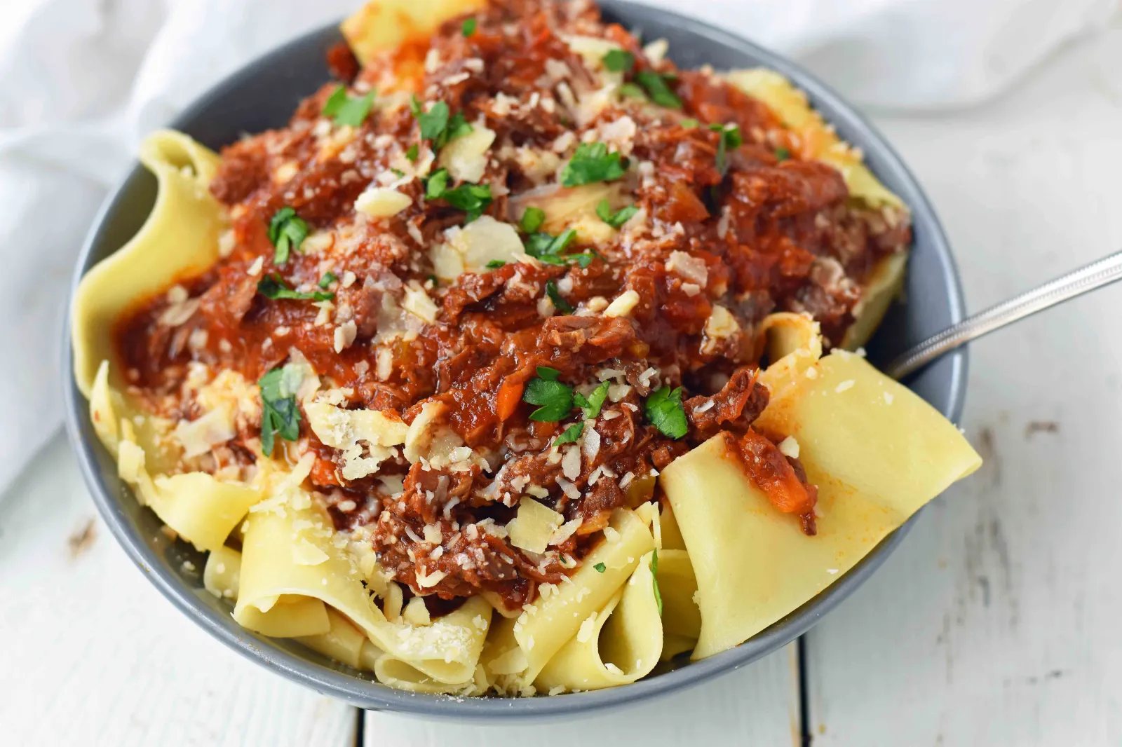 This braised shredded beef ragu with pappardelle pasta can be made in a slow cooker or instant pot pressure cooker. It makes the most tender, flavorful beef in a rich, velvety sauce. It is the ultimate comfort meal in a bowl! This Beef Ragu can be put on top of spiralized vegetables, mashed potatoes, or polenta for a gluten-free dinner. www.modernhoney.com