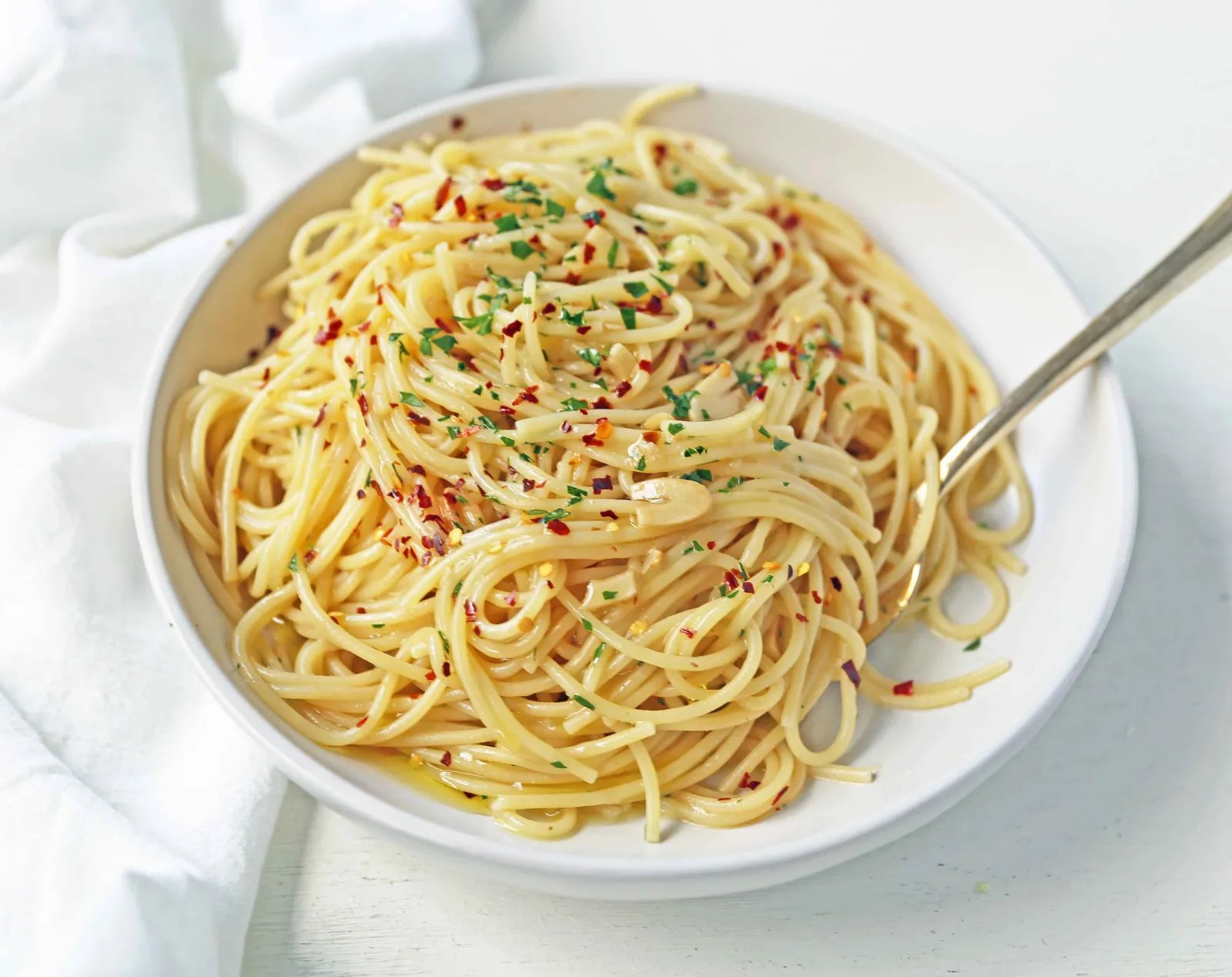 Spaghetti Aglio e Olio. Spaghetti tossed in sauteed garlic, olive oil, red pepper flakes, and fresh parsley. A quick and easy authentic pasta dish! Spaghetti with Garlic and Oil is 20 minute meal. www.modernhoney.com #pasta #spaghetti