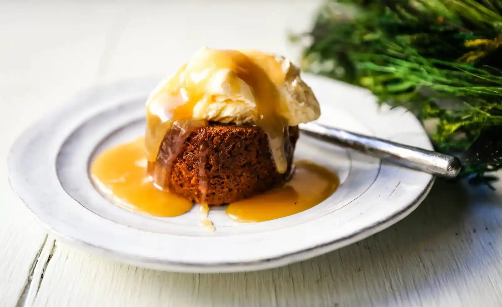 Sticky Toffee Pudding. A famous English dessert with a moist sponge cake covered in a homemade caramel toffee sauce and vanilla ice cream. The perfect Christmas dessert or holiday dessert recipe. A Christmas traditional dessert. www.modernhoney.com #stickytoffeepudding #toffeepudding #stickypudding #datecake