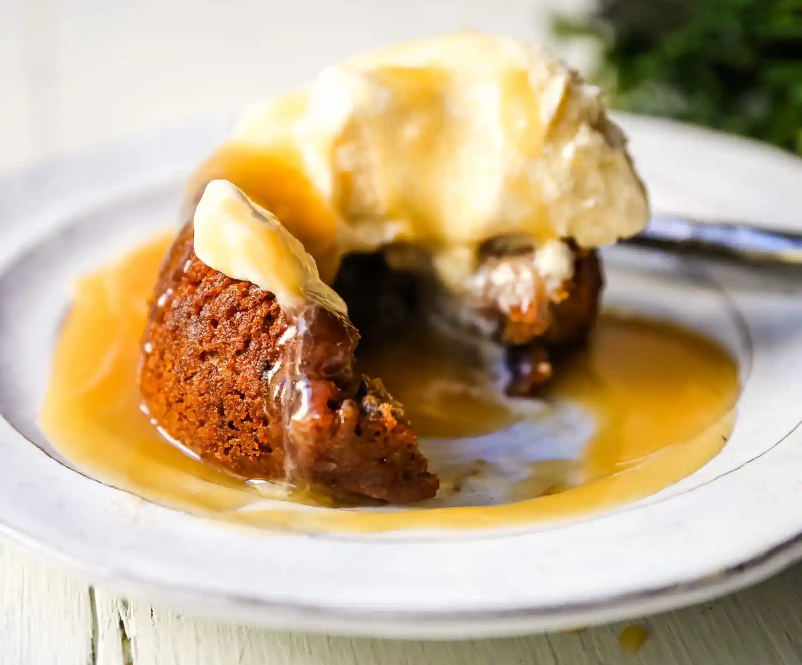 Sticky Toffee Pudding. A famous English dessert with a moist sponge cake covered in a homemade caramel toffee sauce and vanilla ice cream. The perfect Christmas dessert or holiday dessert recipe. A Christmas traditional dessert. www.modernhoney.com #stickytoffeepudding #toffeepudding #stickypudding #datecake