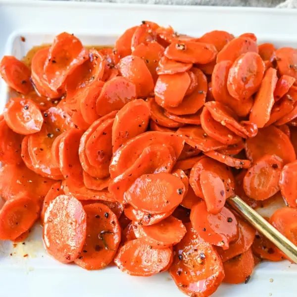 These Roasted Carrots with a Maple Brown Sugar Glaze are carrots roasted in butter, real maple syrup, brown sugar, and a touch of red pepper flakes. These maple glazed carrots are sweet and savory and a perfect side dish recipe.