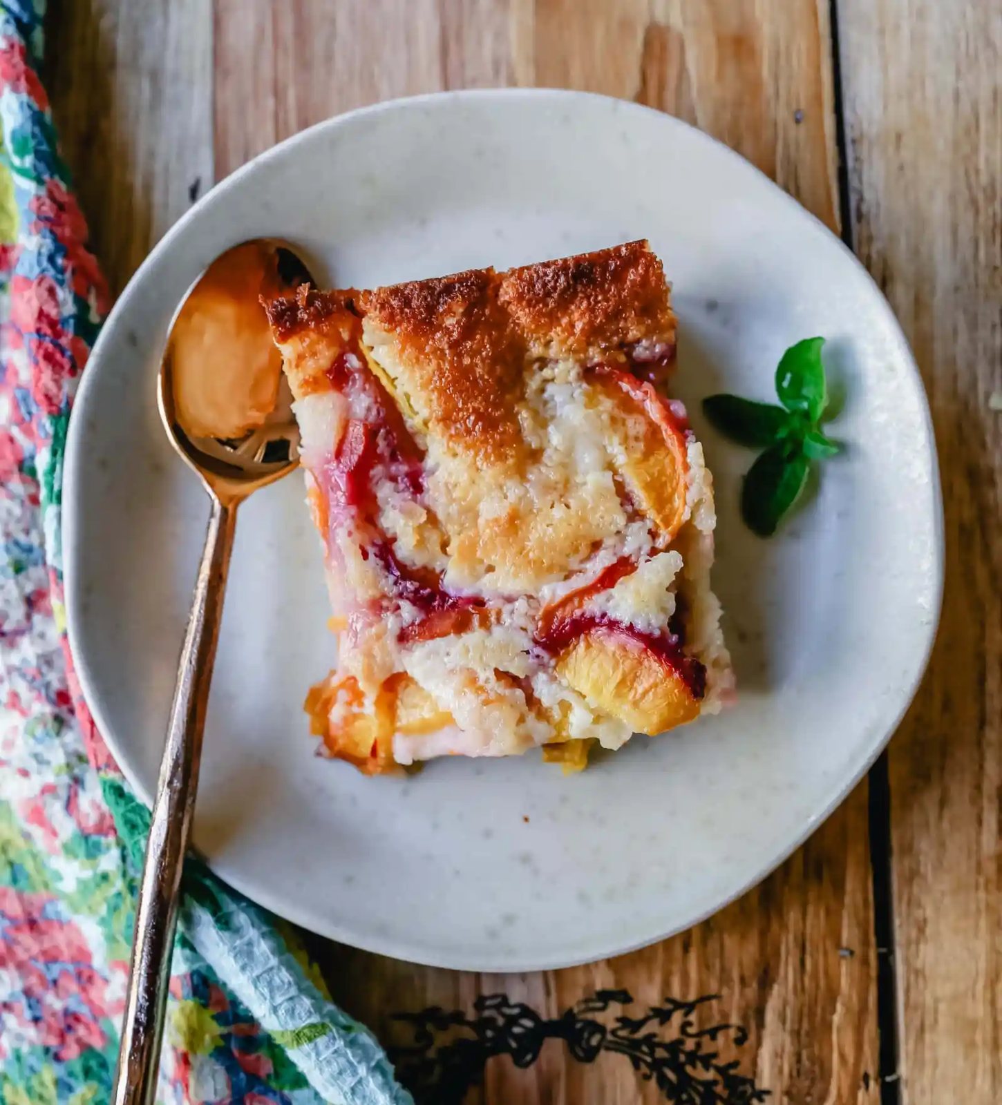 Texas Style Peach Cobbler. Fresh peaches sweetened with sugar and topped with a creamy buttery cake-like topping. A Texas favorite dessert! #peaches #peachdessert #peachcobbler