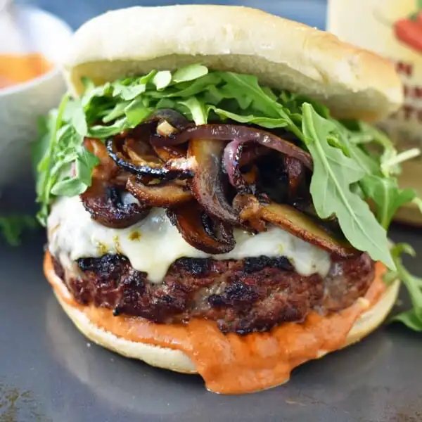 The Big Boss Burger made with seasoned ground beef, creamy pepper jack cheese, sauteed butter mushrooms and onions with a sriracha sun dried tomato aioli. A burger with a little kick! www.modernhoney.com