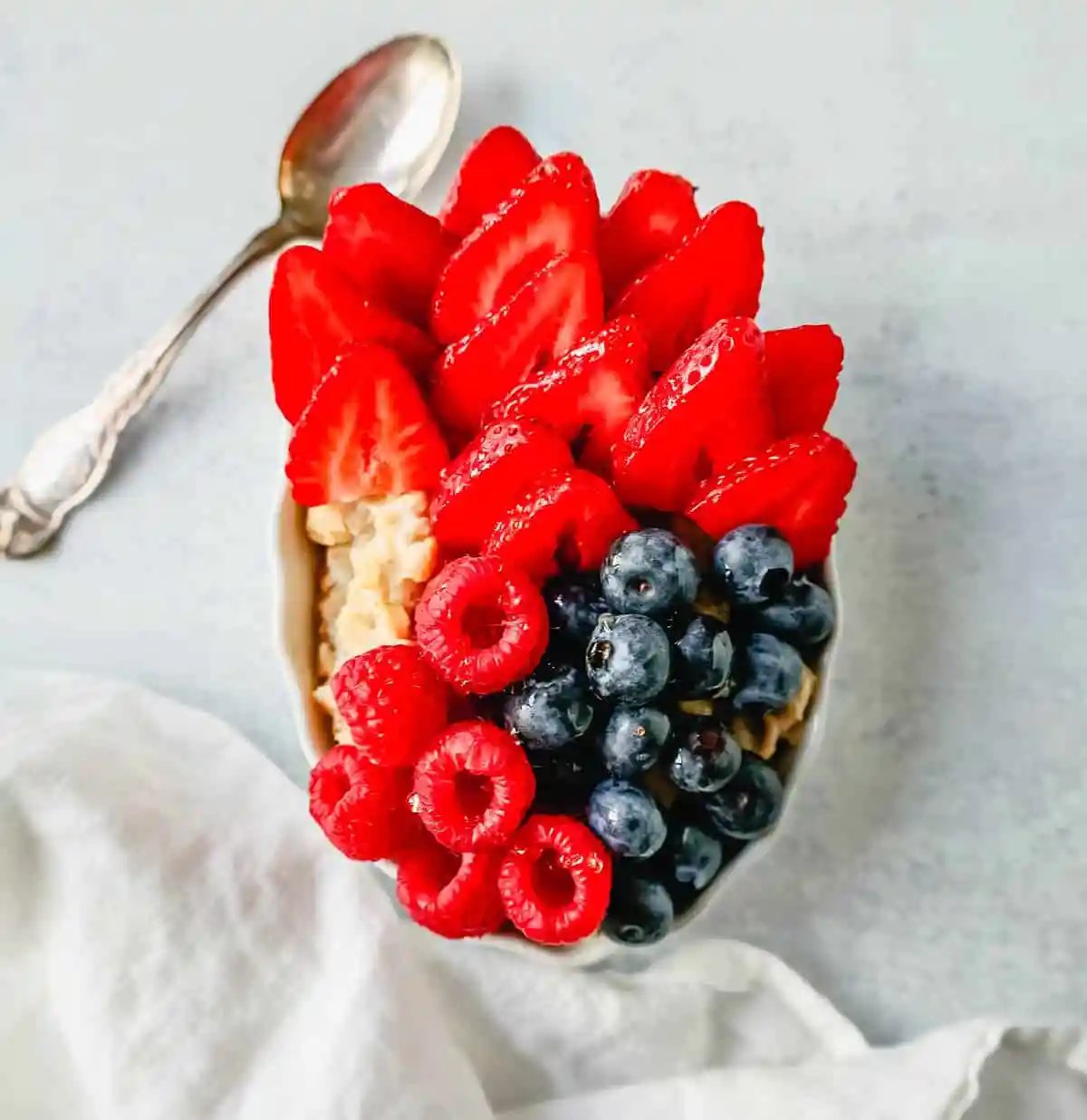 Blueberry Strawberry Oatmeal. How to make creamy oatmeal with your favorite toppings combinations. I am sharing a list of all of the popular oatmeal toppings ideas to serve on a cold winter day and how to make the best bowl of oatmeal!