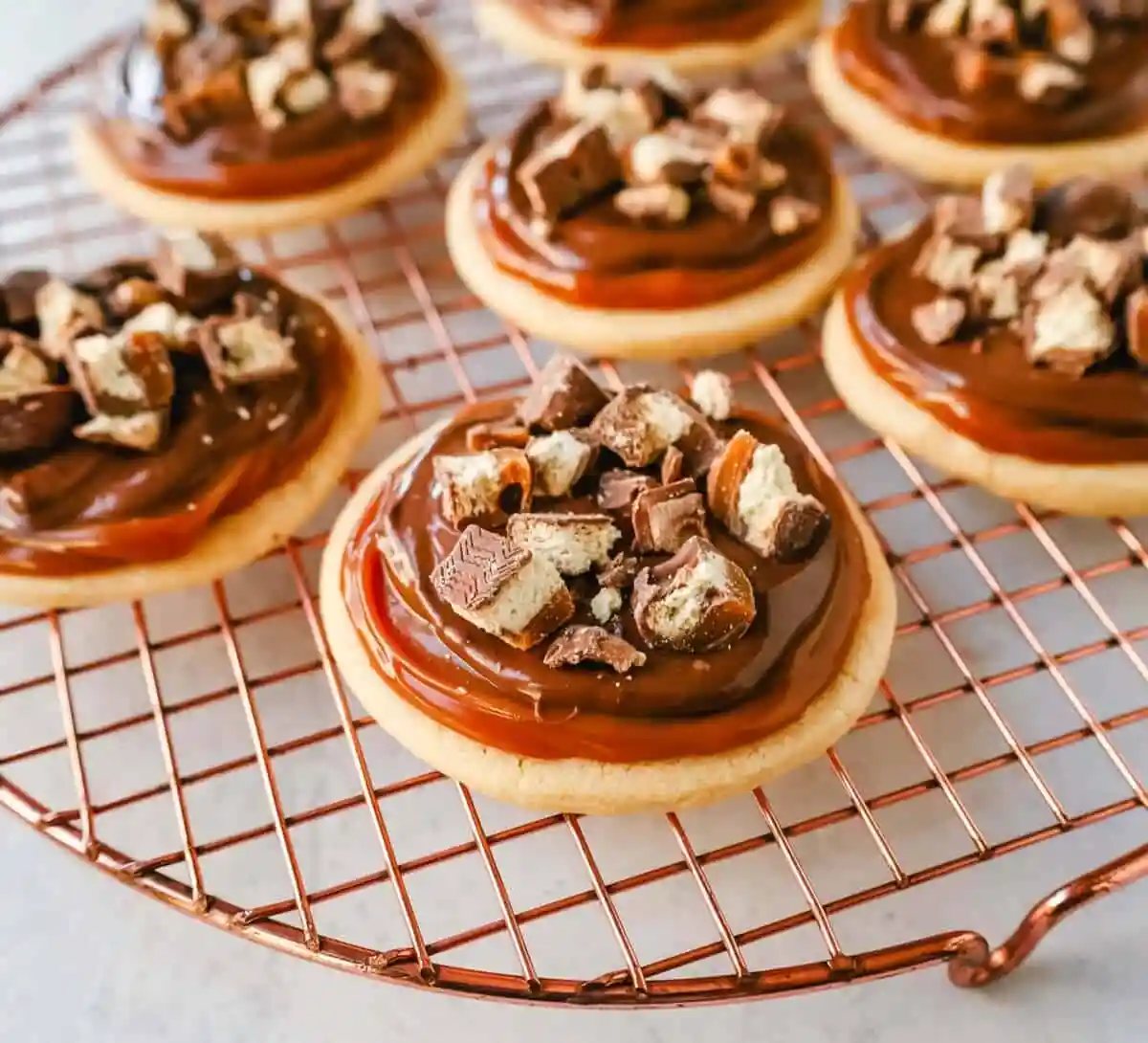 Twix Cookies made with soft sugar shortbread topped with rich caramel and milk chocolate and sprinkled with chopped Twix candy bars. These Millionaire Cookies are the best chocolate caramel shortbread cookie!