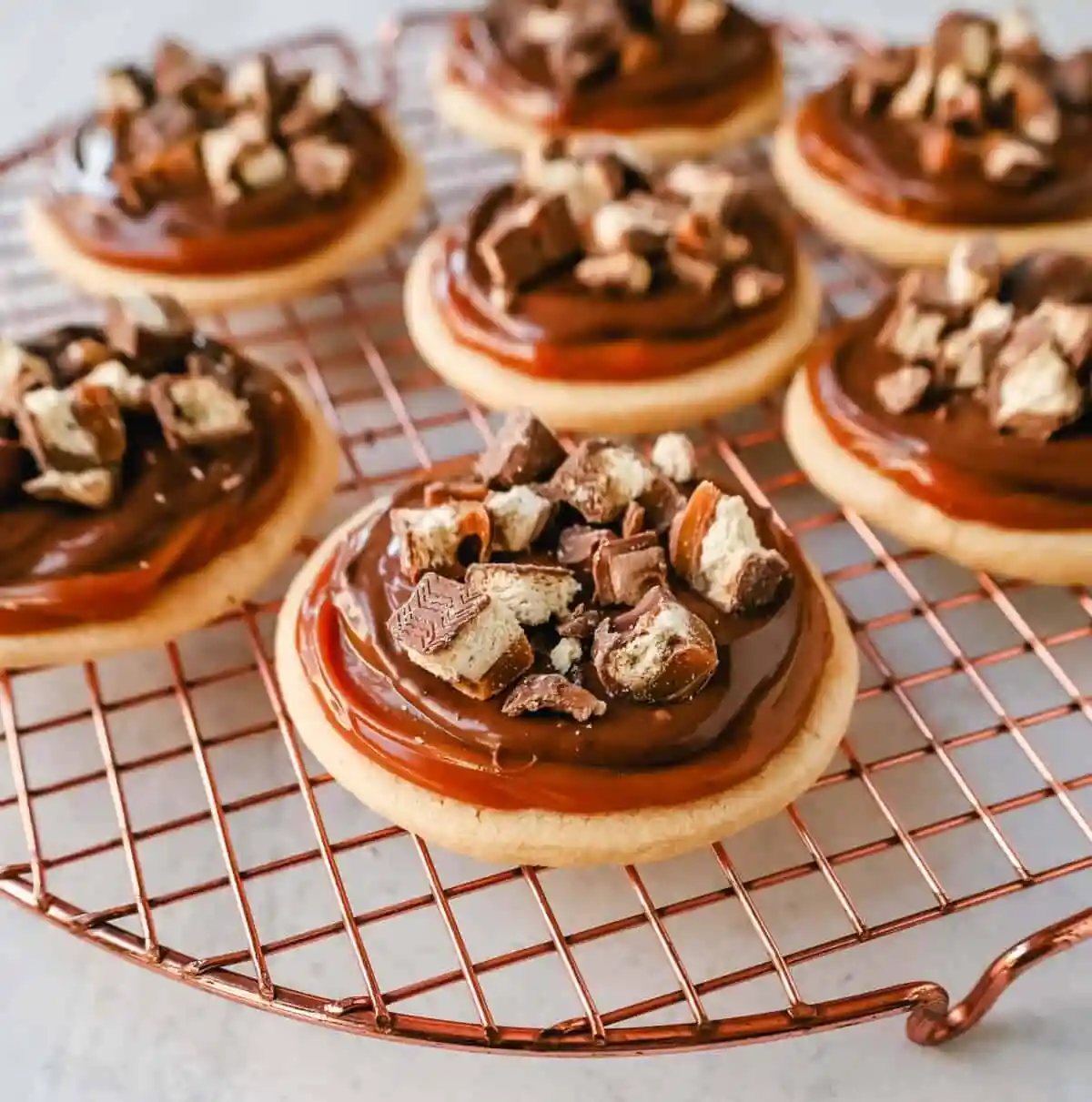 Twix Cookies made with soft sugar shortbread topped with rich caramel and milk chocolate and sprinkled with chopped Twix candy bars. These Millionaire Cookies are the best chocolate caramel shortbread cookie!