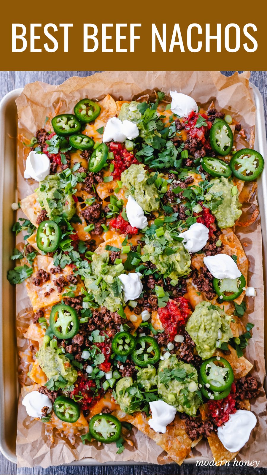 Ground Beef Nachos Recipe Seasoned ground beef with crispy tortilla chips, Mexican cheeses, fresh guacamole, sour cream, jalapenos, fresh salsa, green onions, and cilantro make the best beef nachos!